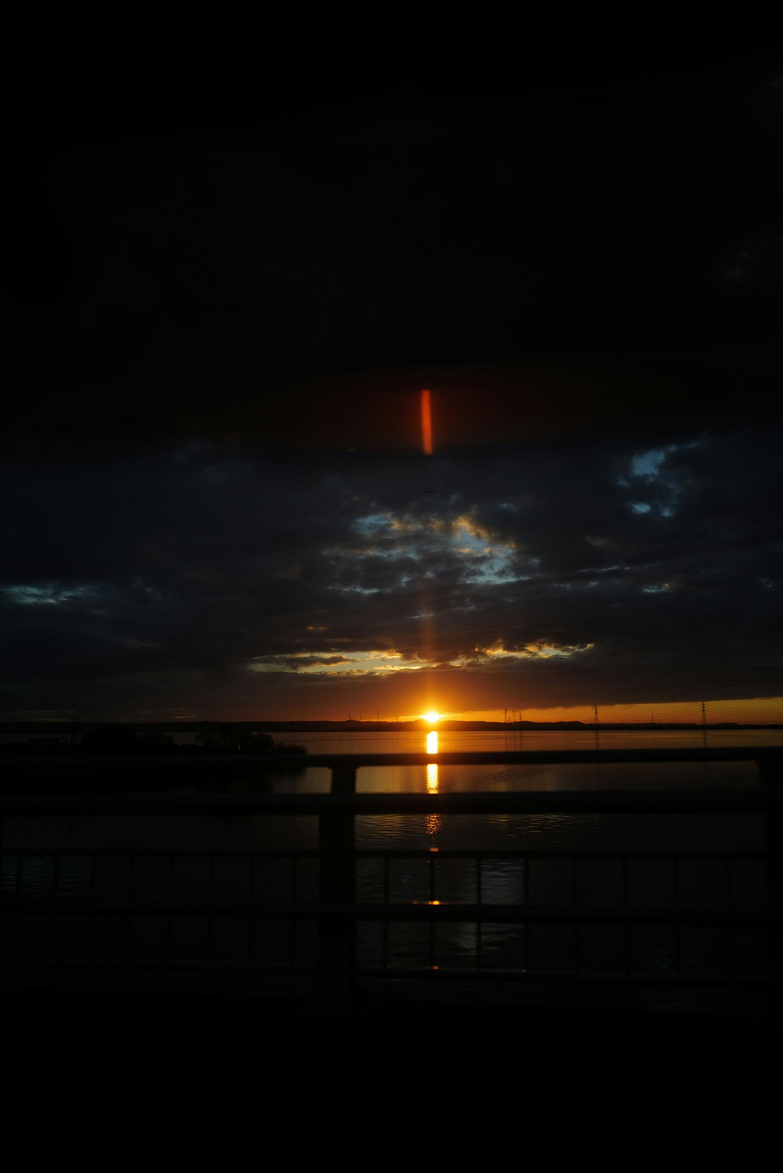 Beautiful sunset reflecting on water dark clouds with orange light