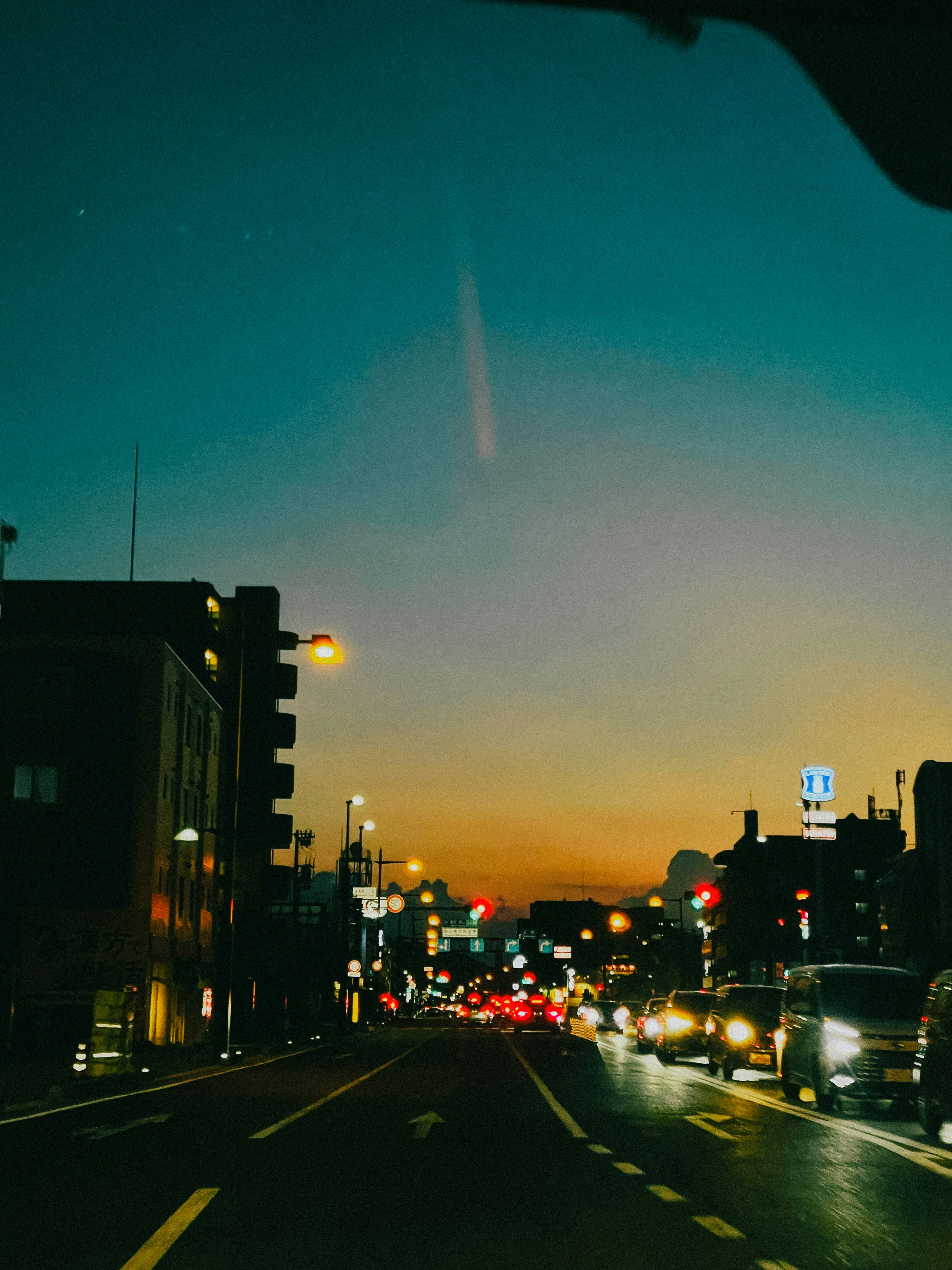 夜の街道を走る車のテールライトが続く風景