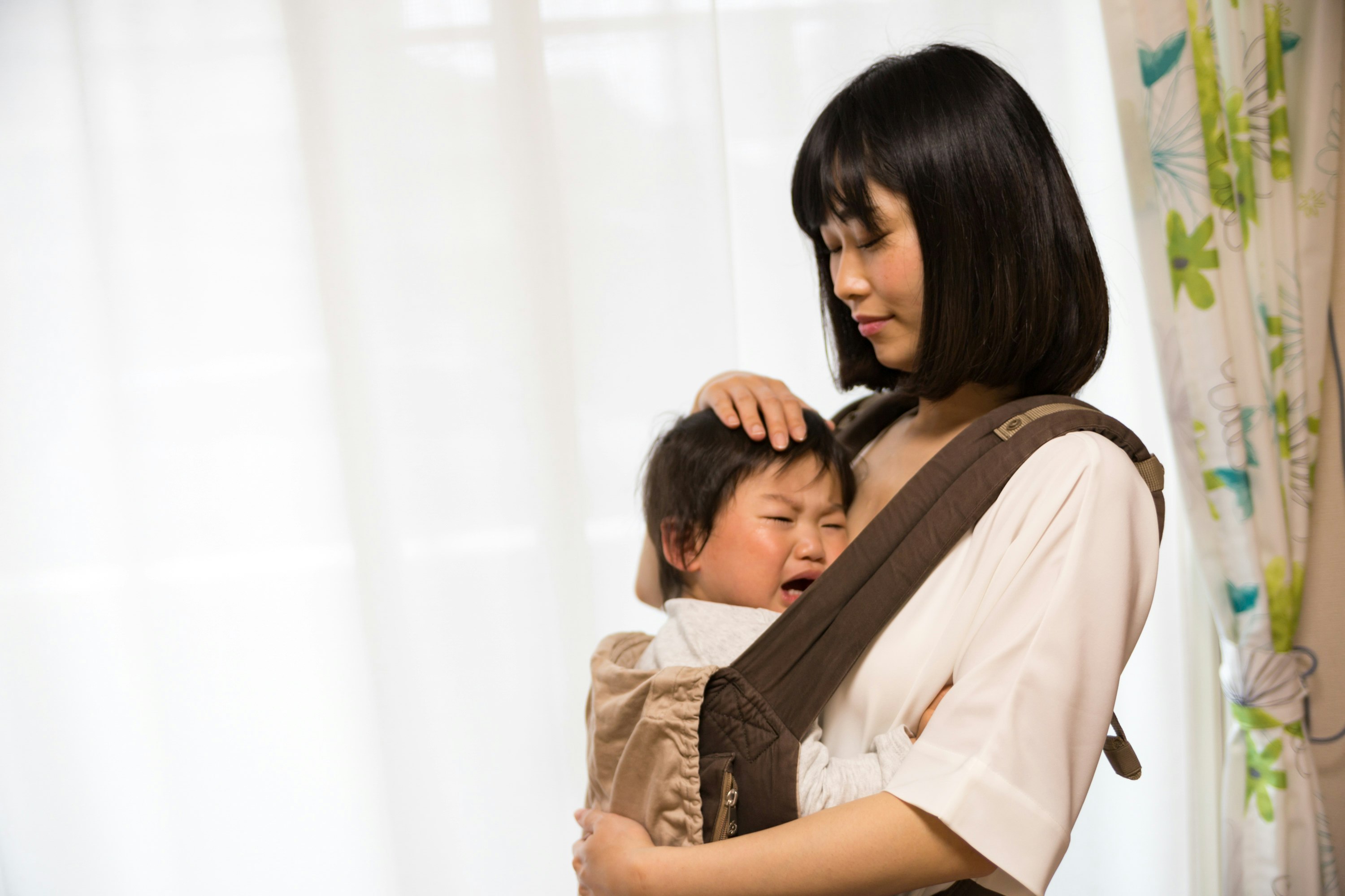 抱っこしてあやす母親と赤ちゃんの室内シーン