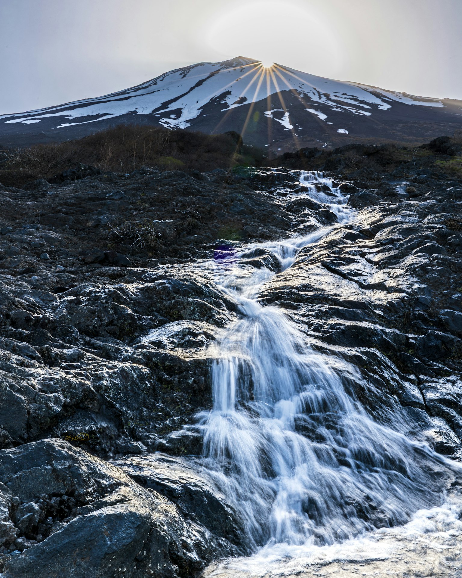 雪をかぶった山と流れる水の美しい風景
