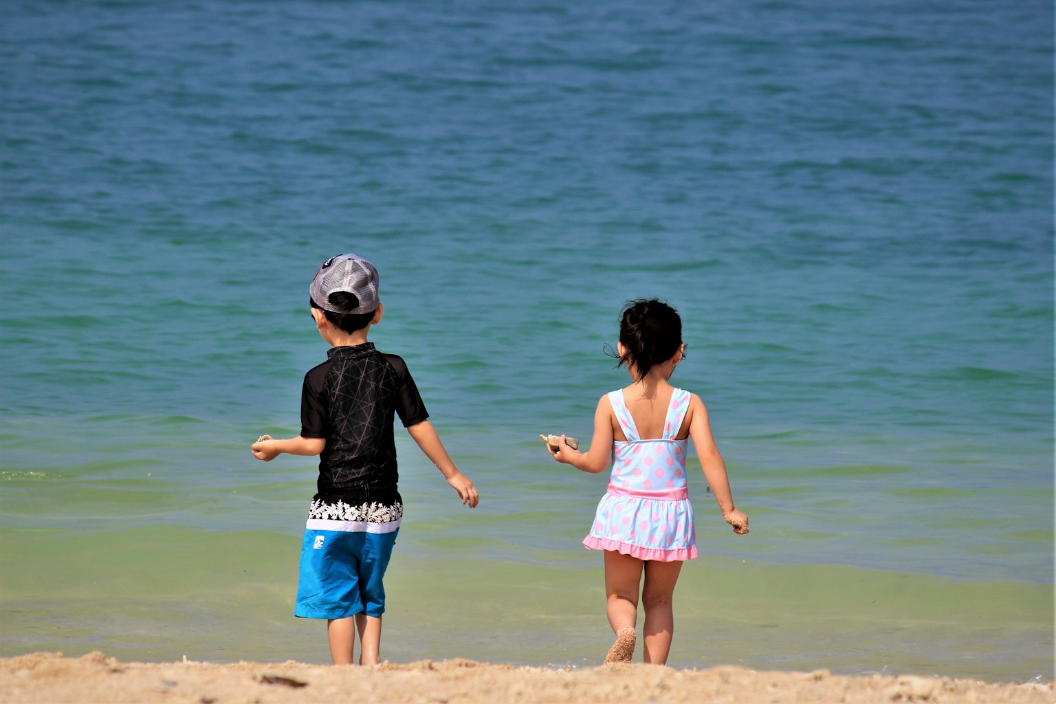 Anak-anak bermain di pantai melihat ke laut
