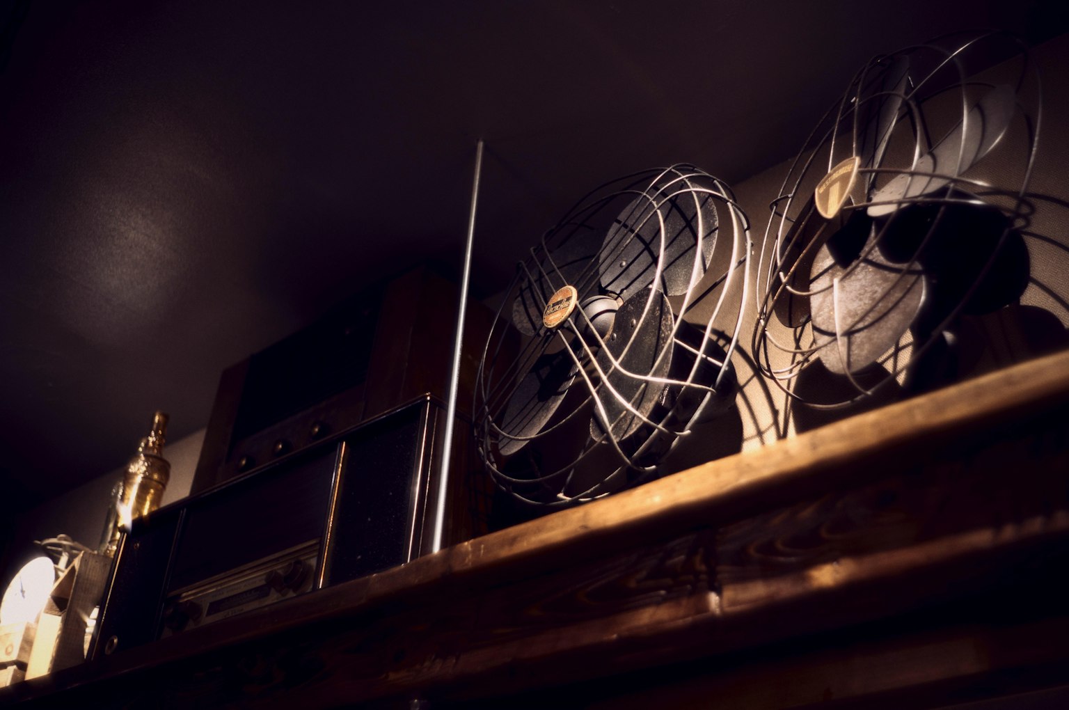 Des ventilateurs vintage et une radio rétro exposés sur une étagère