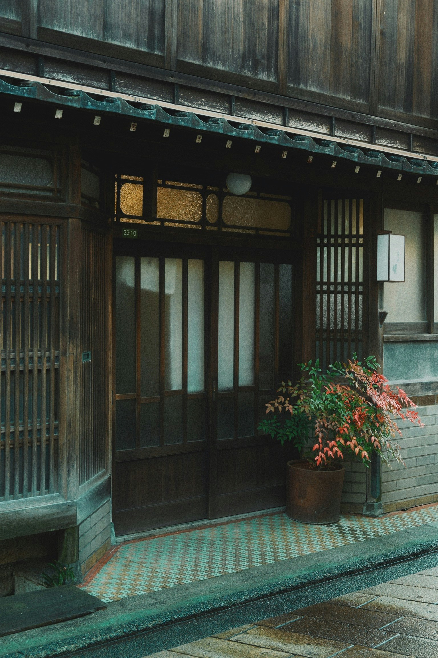 传统日本住宅的入口，木门和格子窗，带有花盆