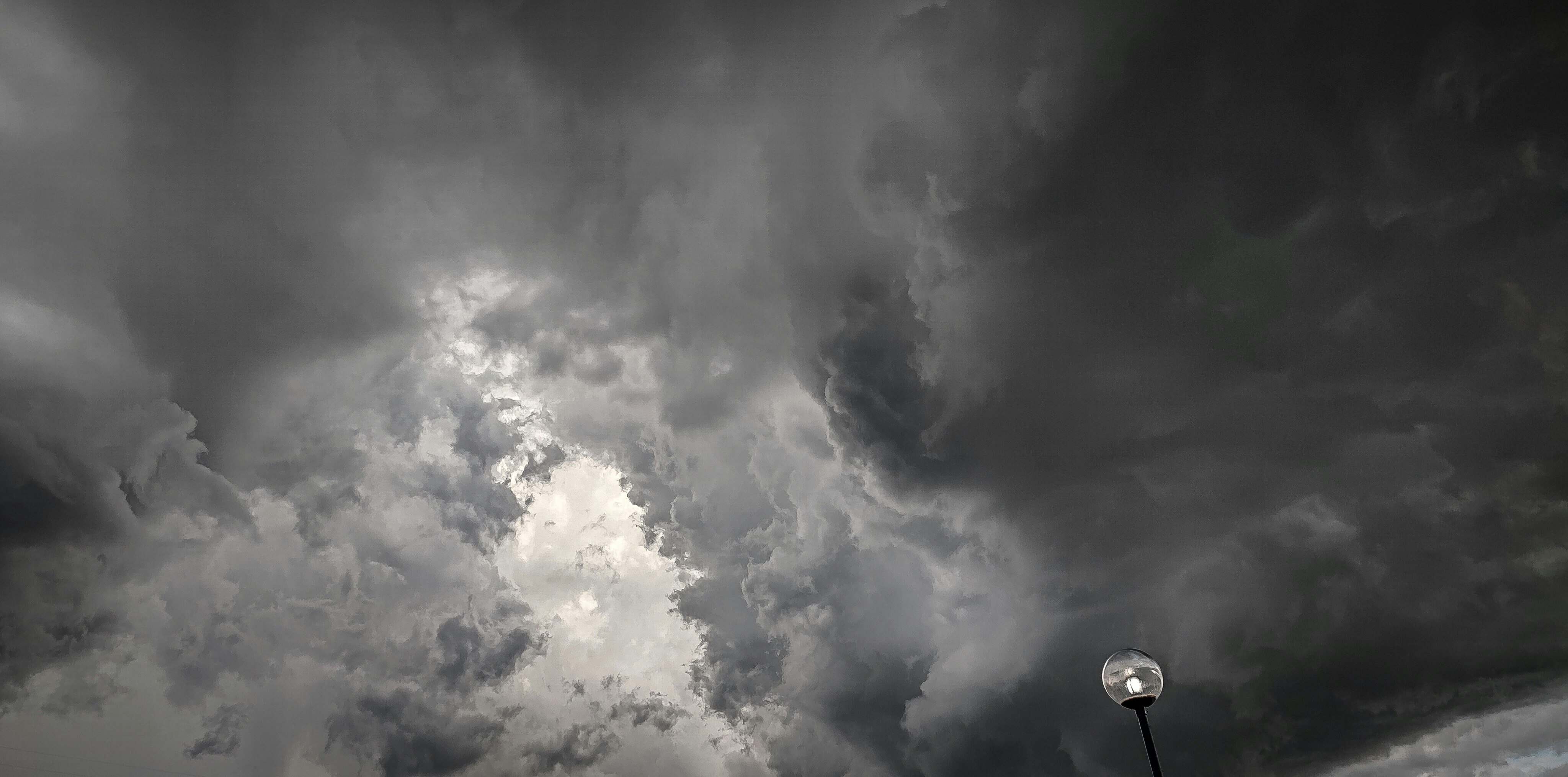 黒雲の下で街灯が灯る雨雲の迫る空