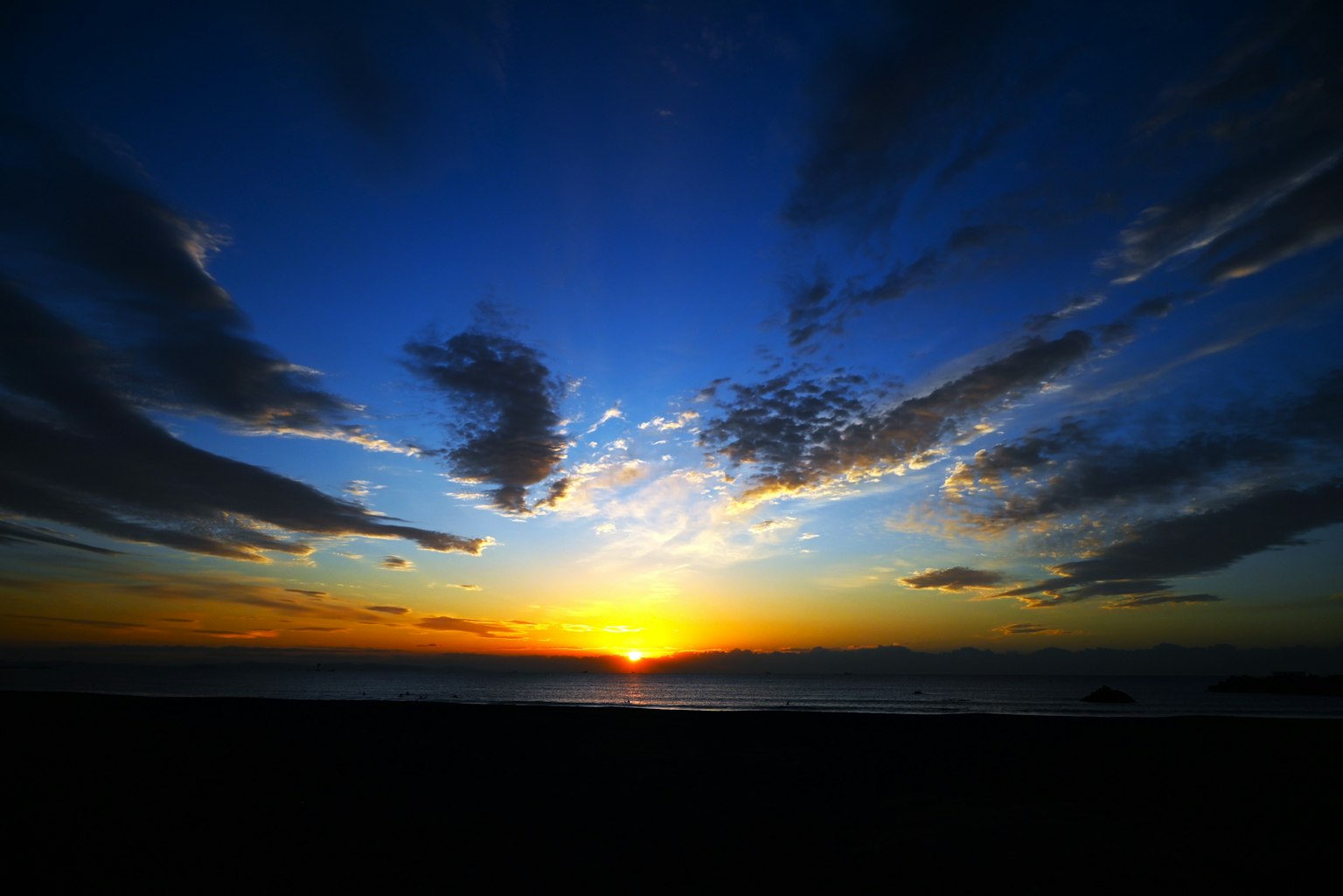 Hermoso atardecer sobre el mar con cielo azul y sol naranja