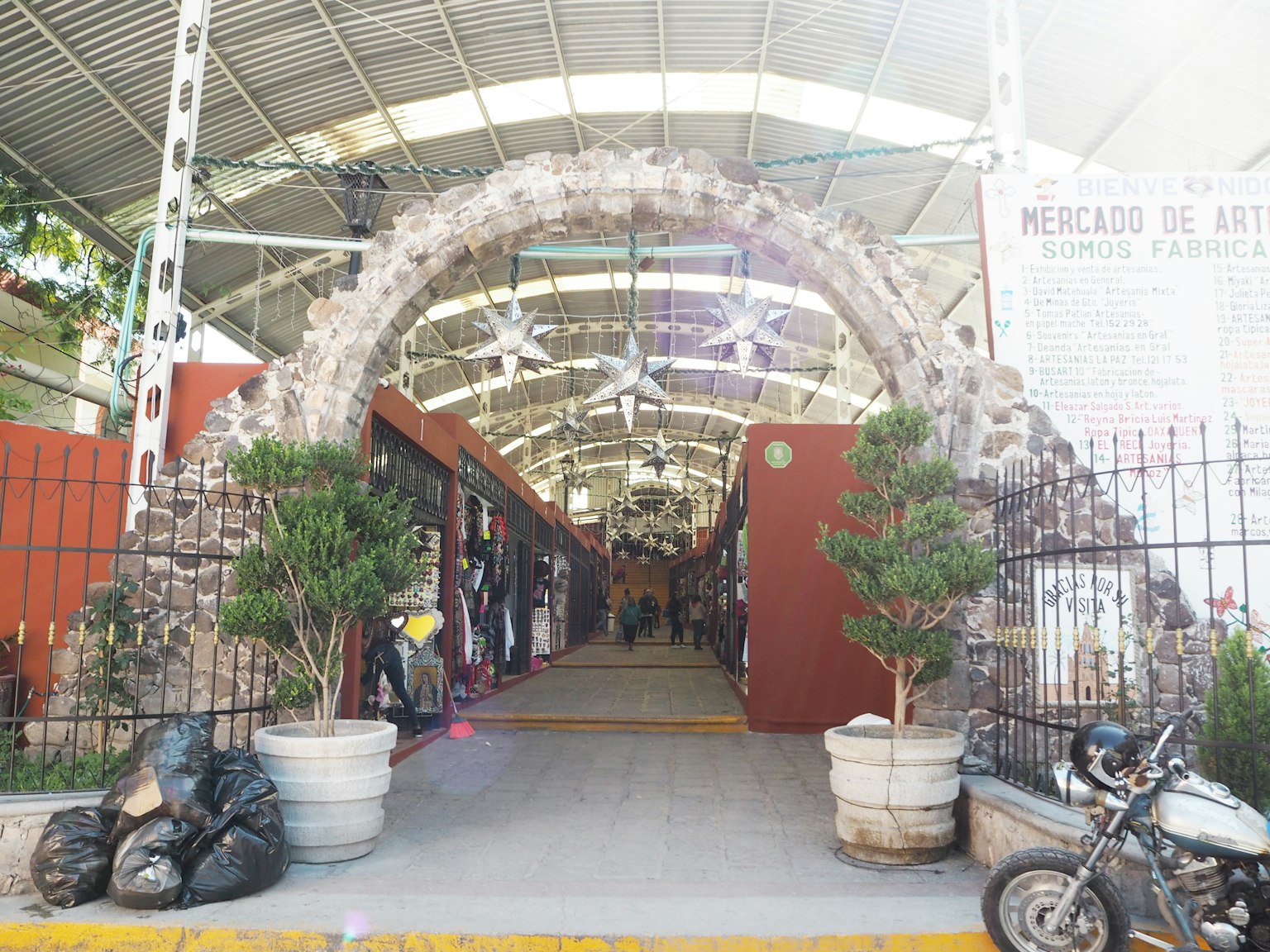 Entrée d'un marché avec une arche en pierre décorée de plantes en pot