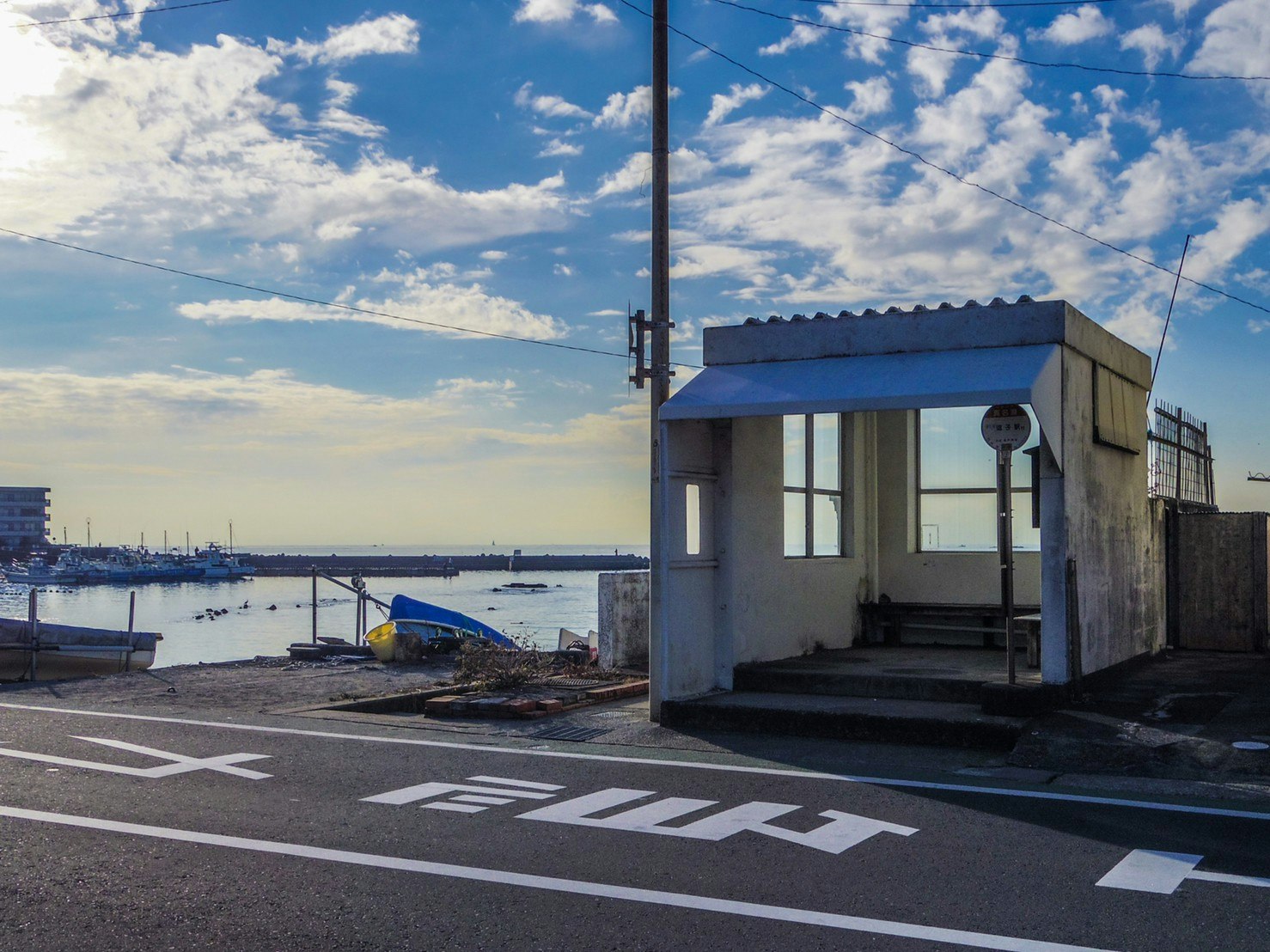 Seaside small waiting shelter at a street intersection under a blue sky