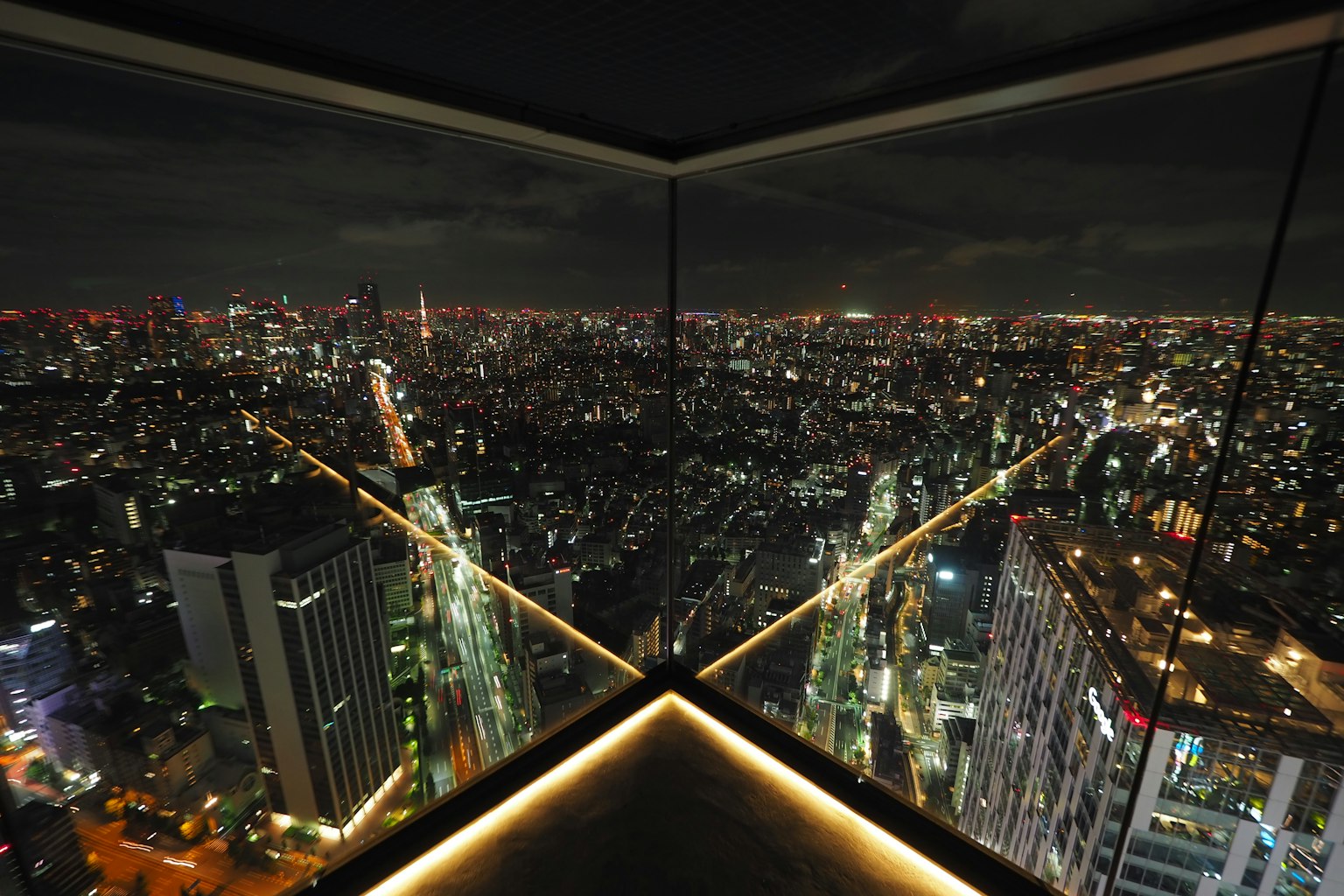 View of Tokyo's cityscape at night from a high-rise building window