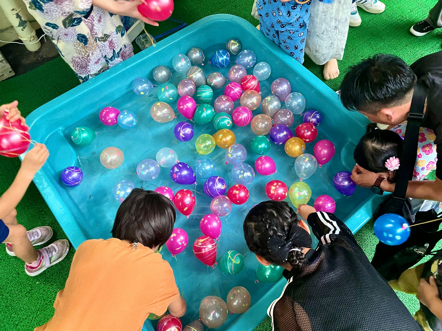孩子们在水中玩五颜六色的球