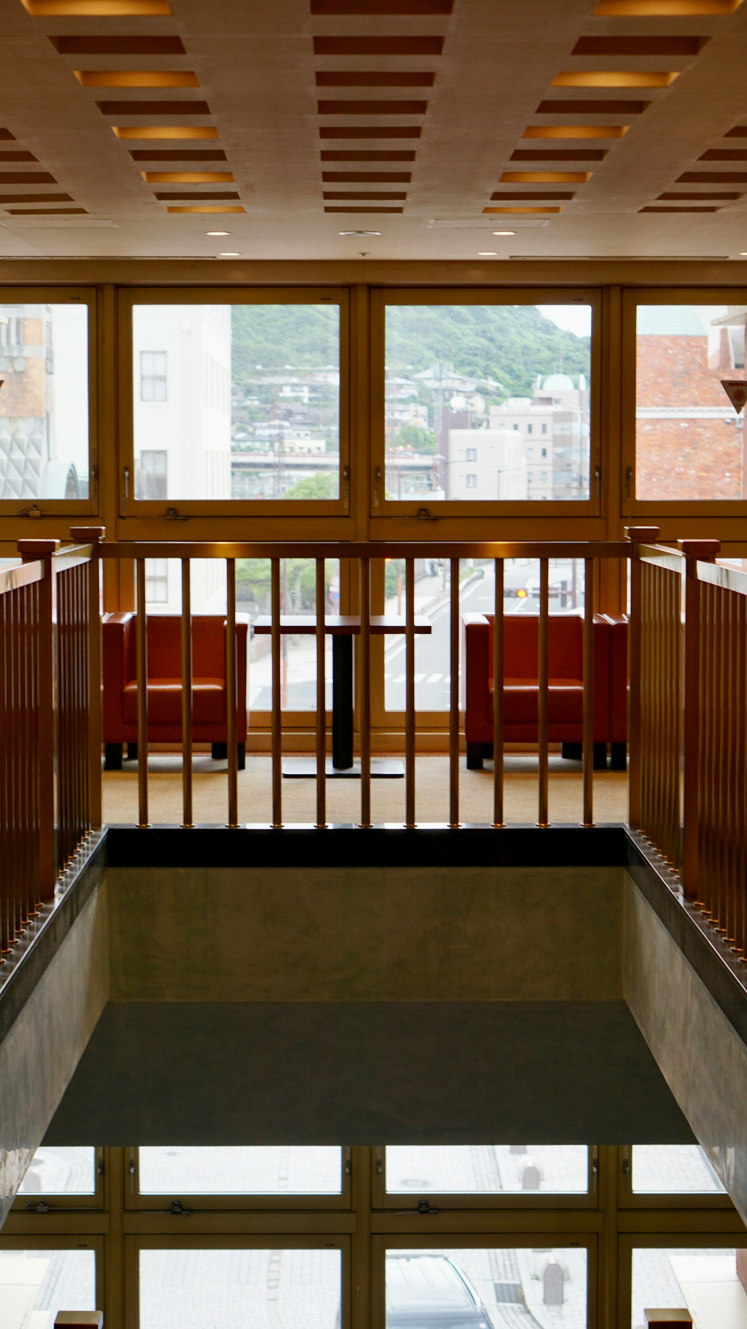 Modernes Lobby-Interieur mit hellen Fenstern reflektierendem Boden und Holzbalustrade