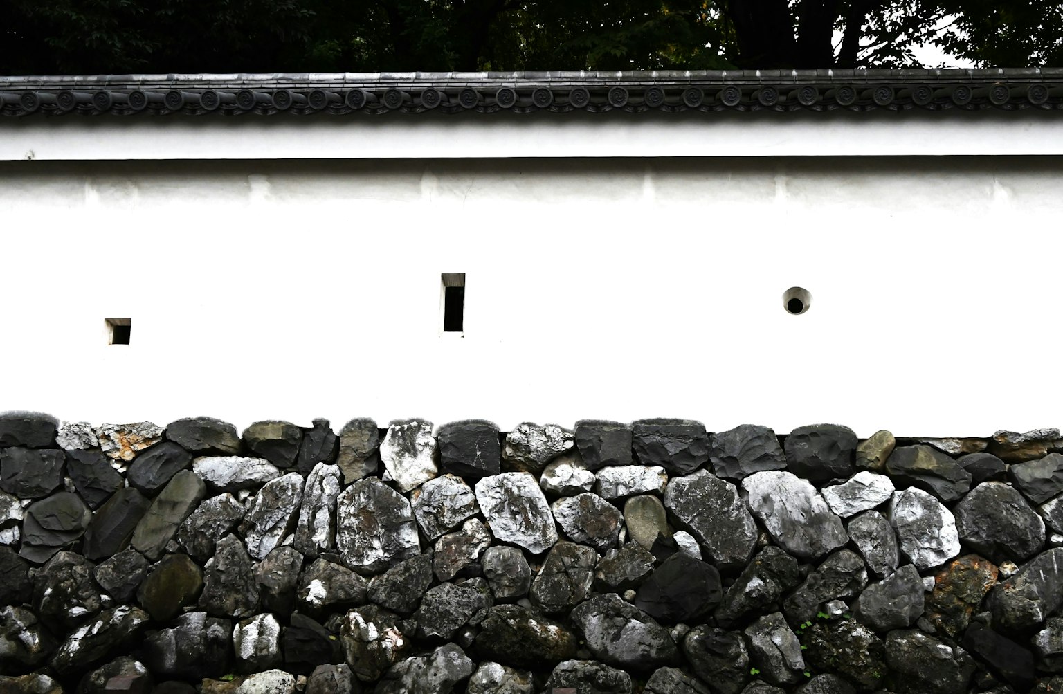 Architettura giapponese tradizionale con un muro bianco e fondazione in pietra