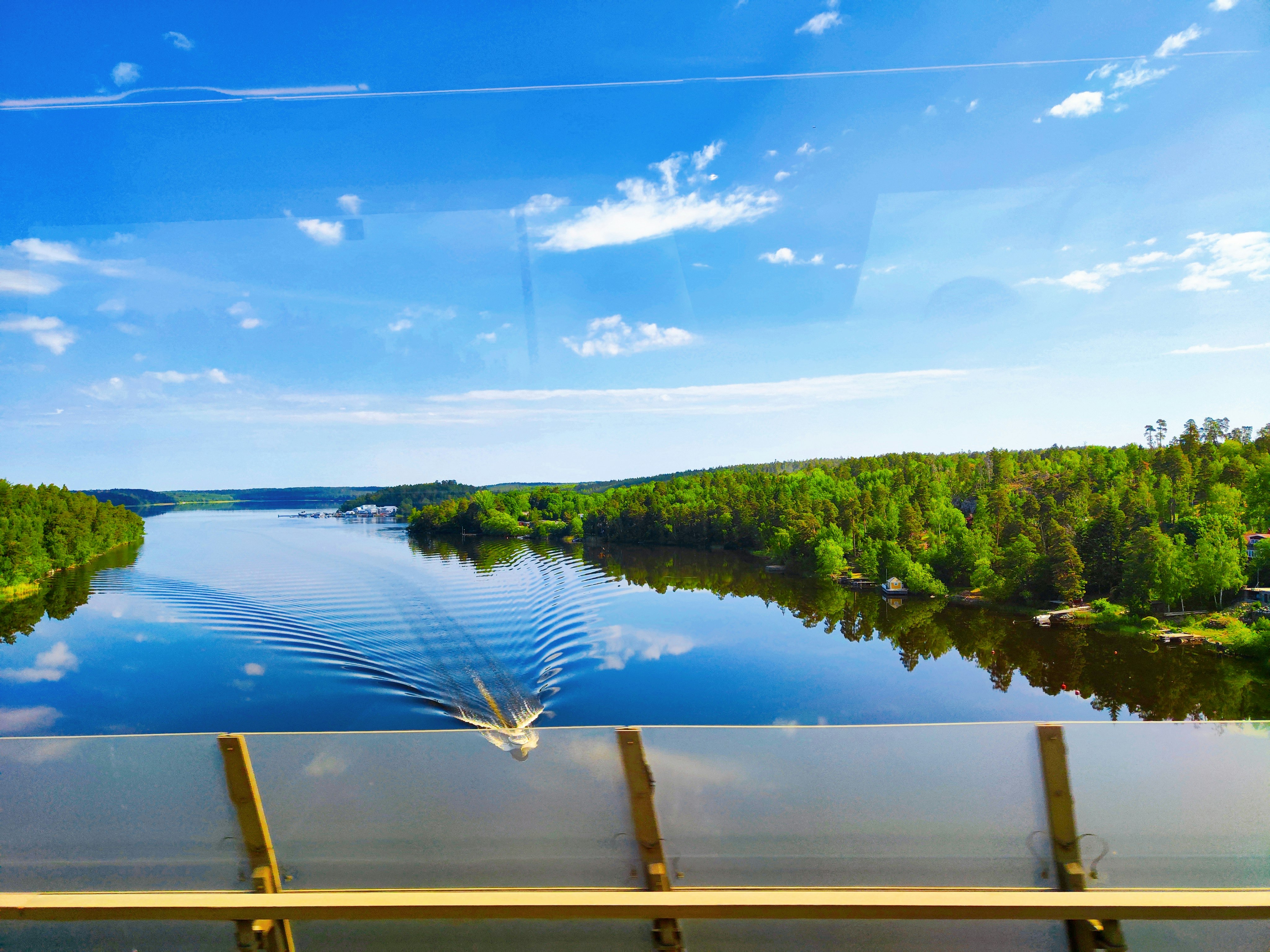 blauer Himmel und ruhige Flussansicht durch ein Fenster