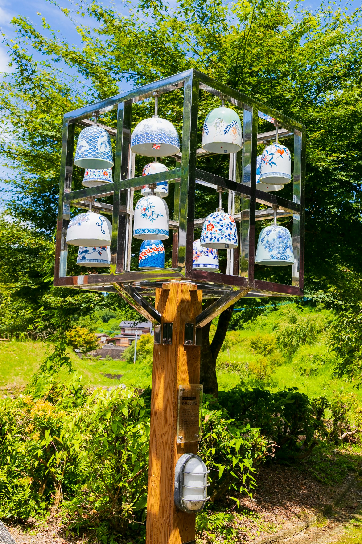 Scultura decorativa di campane con design colorati sotto un cielo blu