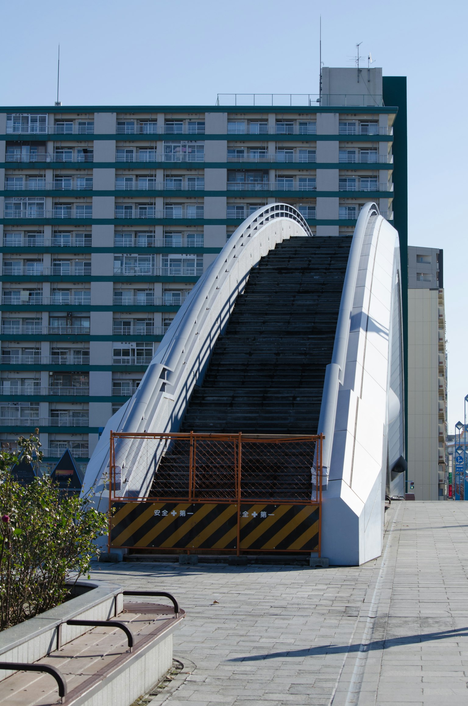 Pont en arc blanc en position surélevée avec un immeuble en arrière-plan