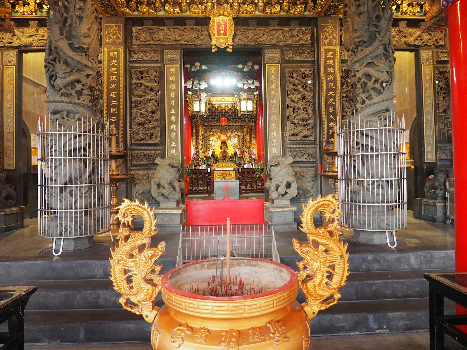 Interno di un tempio con decorazioni intricate e un bruciatore d'incenso dorato