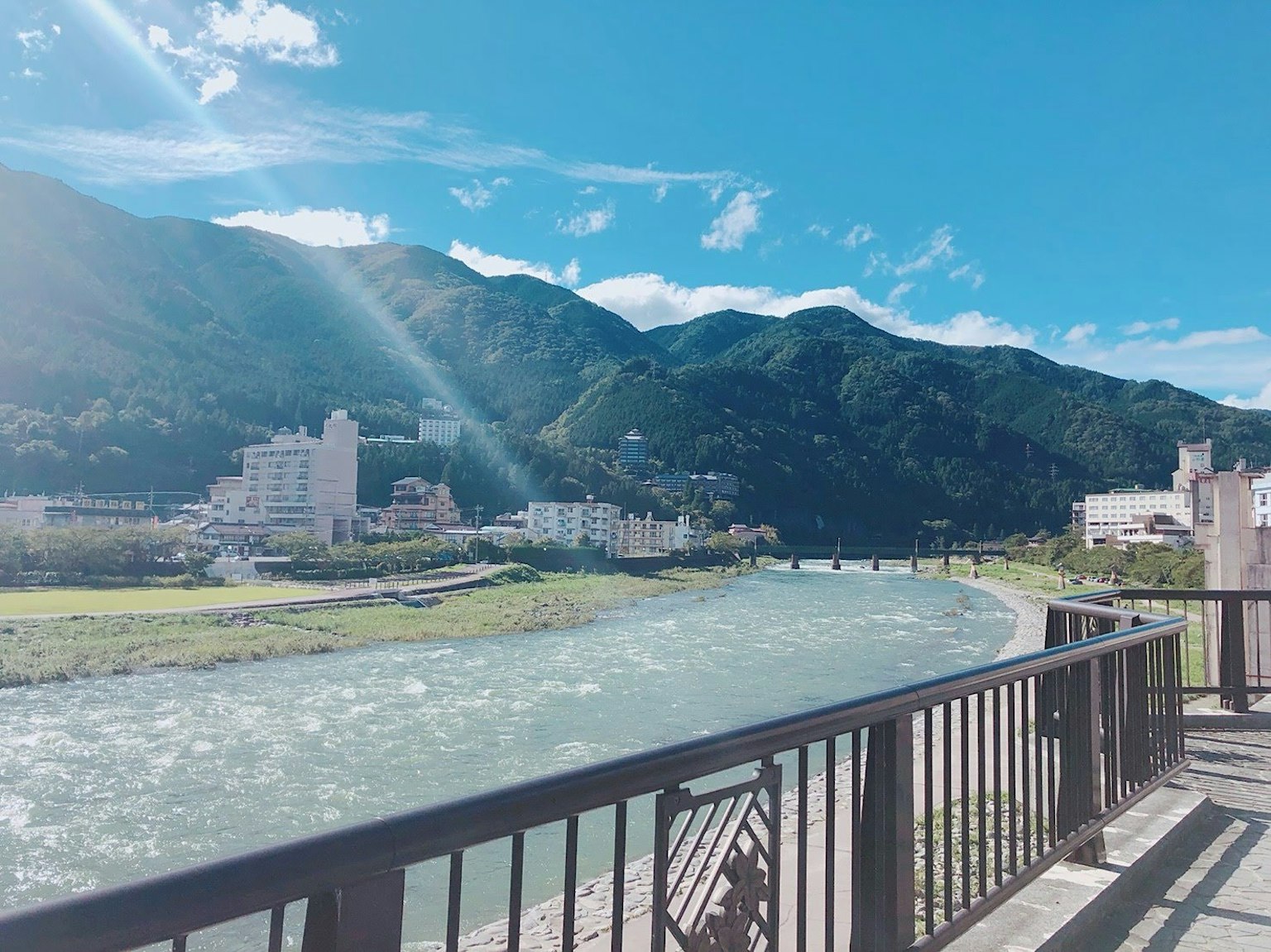 Scenic view of a river and mountains under a blue sky