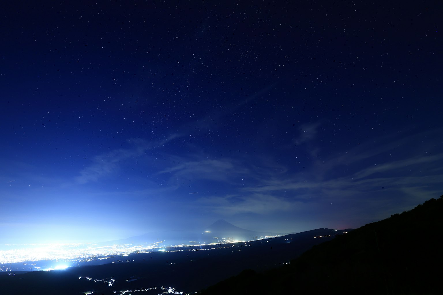 Paysage magnifique avec un ciel étoilé et des lumières de la ville