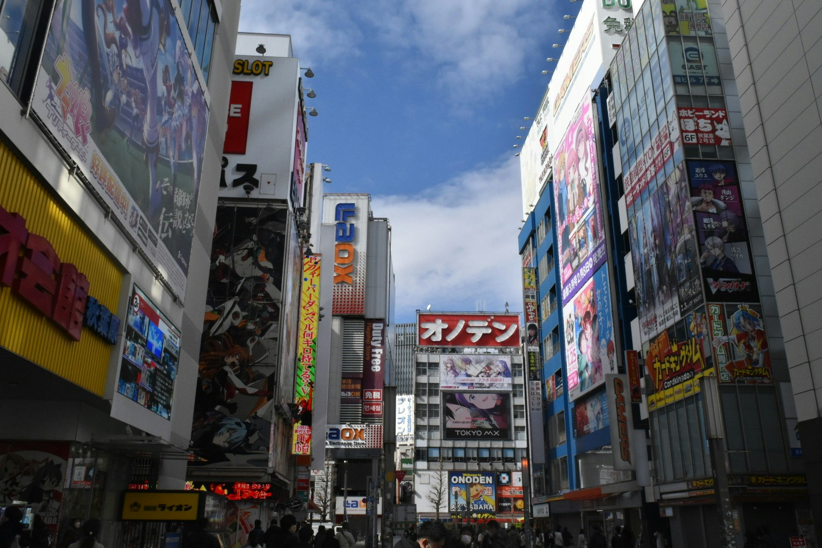 看板やポスターが並ぶ繁華街の路上風景