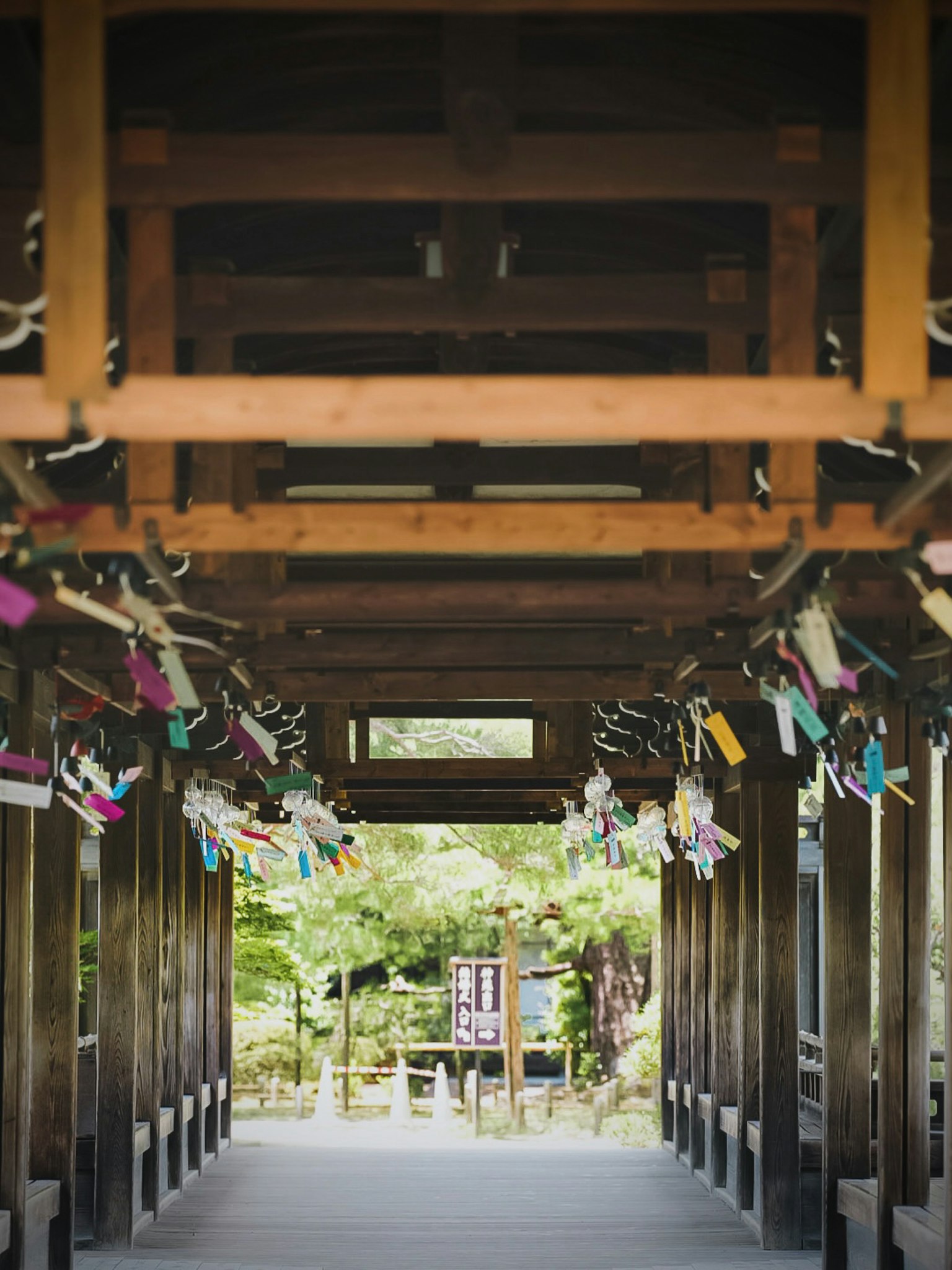 Corridoio ad arco in legno adornato con desideri colorati appesi al soffitto