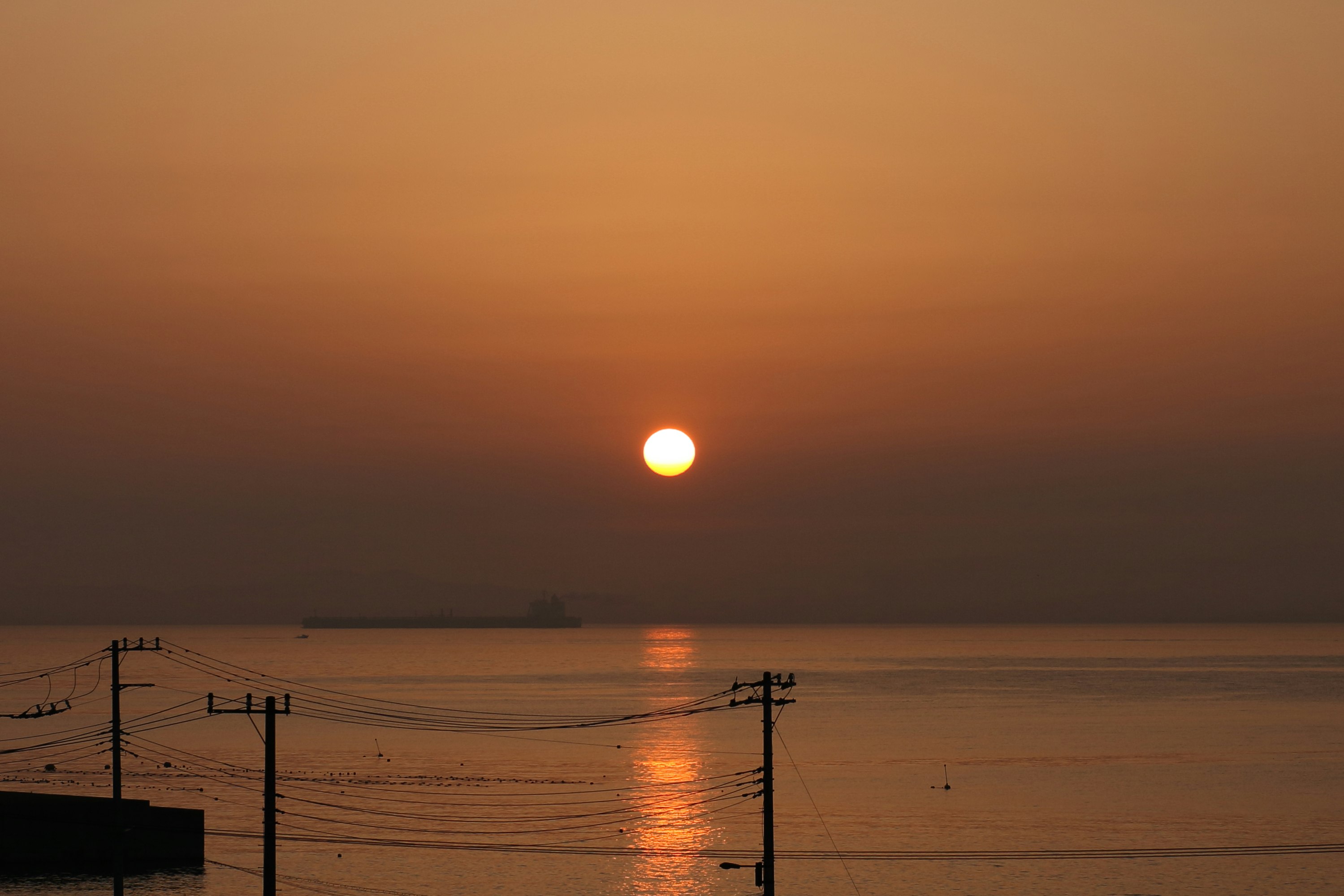 夕日に照らされる海と水平線の風景