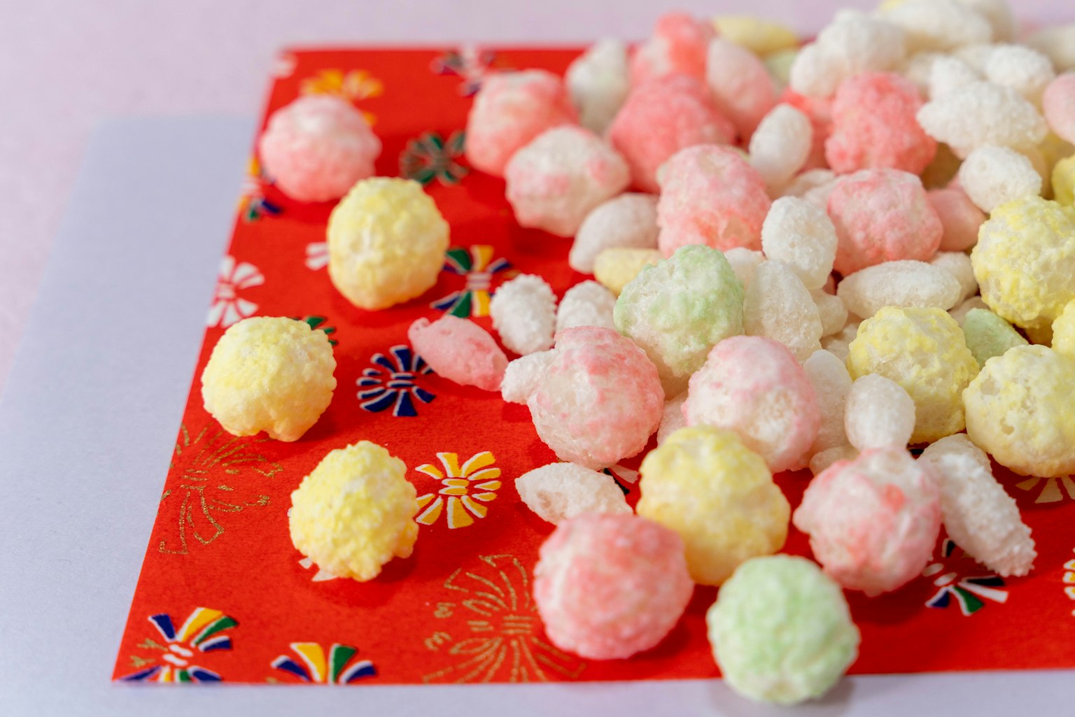 Snack leggeri colorati sparsi su carta decorativa rossa