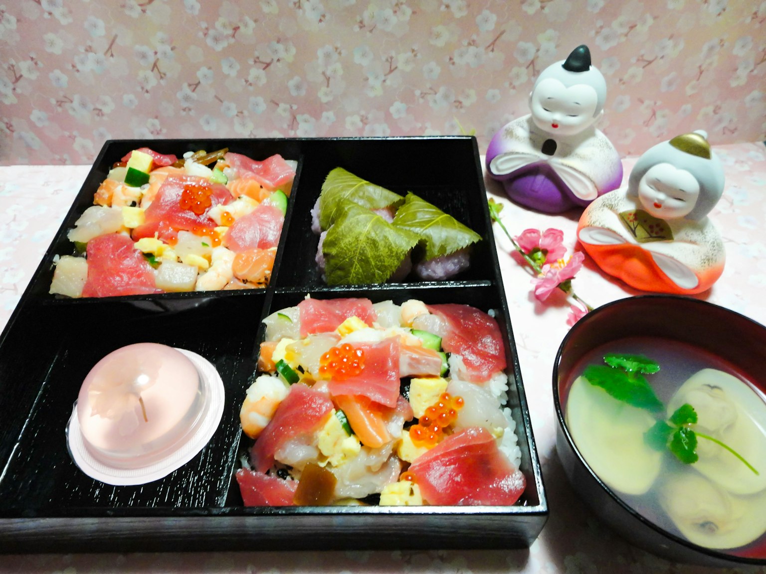 Sushi chirashi yang berwarna-warni dan sup bening disajikan dalam hidangan Jepang yang elegan