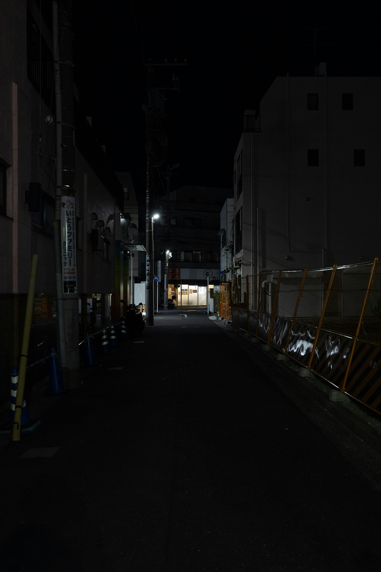 夜晚安靜的巷子，遠處有燈光的建築