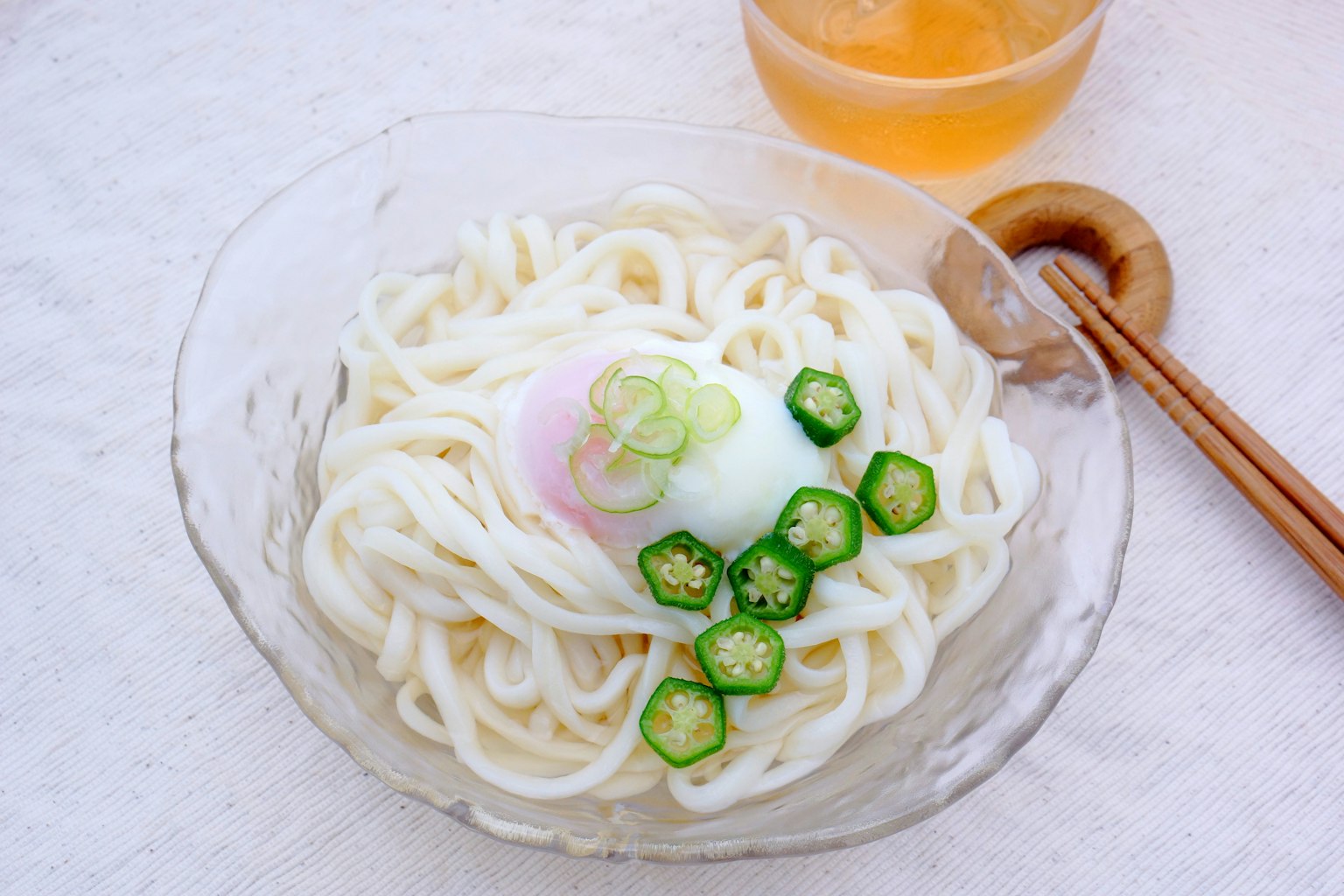 Fideos udon fríos cubiertos con un huevo escalfado y rodajas de okra
