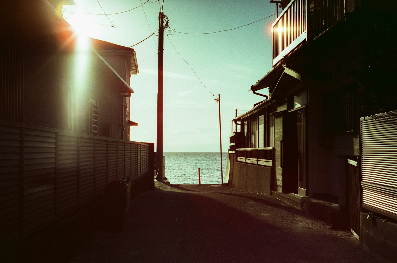 Quiet path leading to the sea with houses on either side