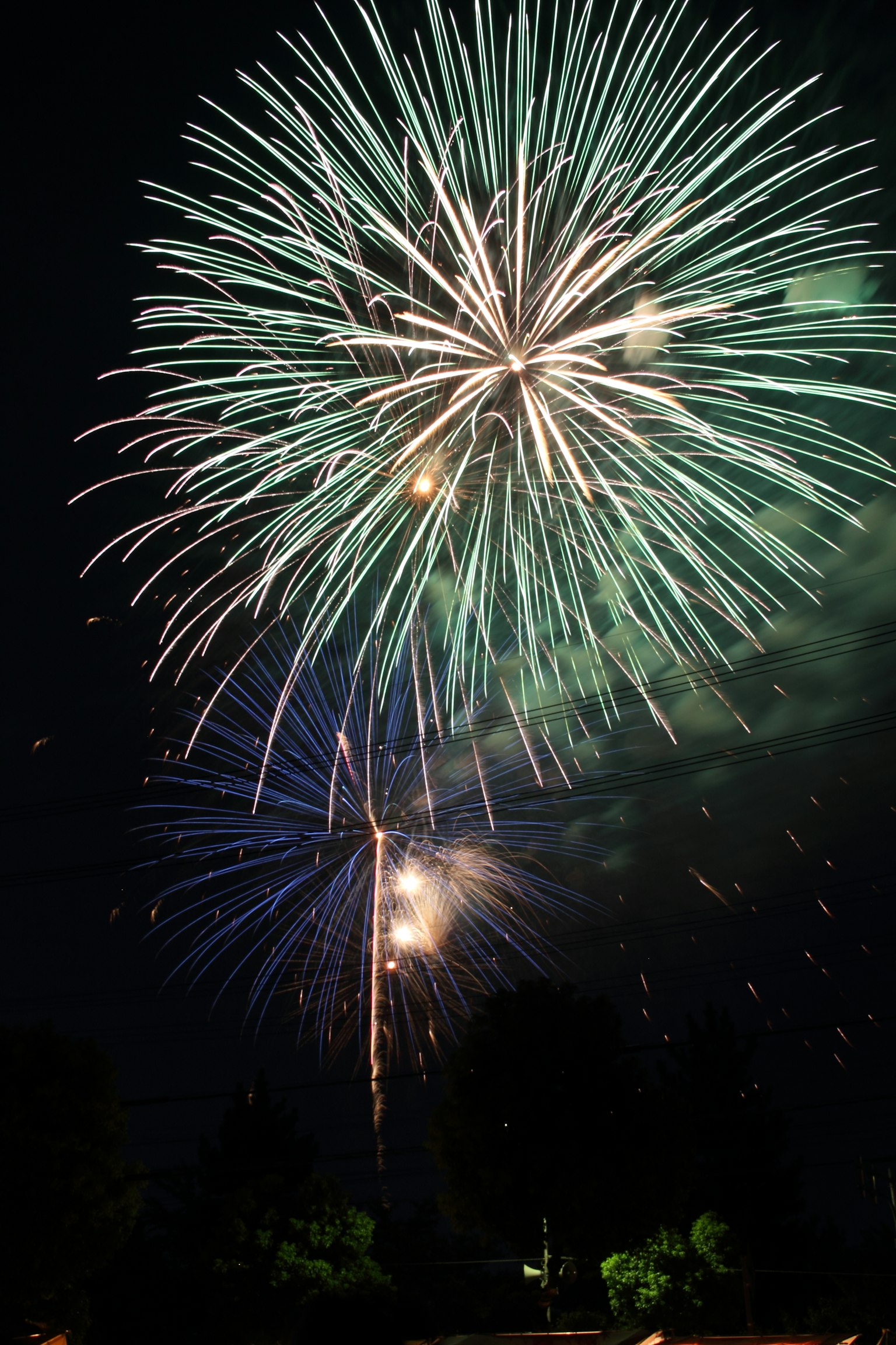 Schöne Feuerwerkshow mit grünen und blauen Farben am Nachthimmel