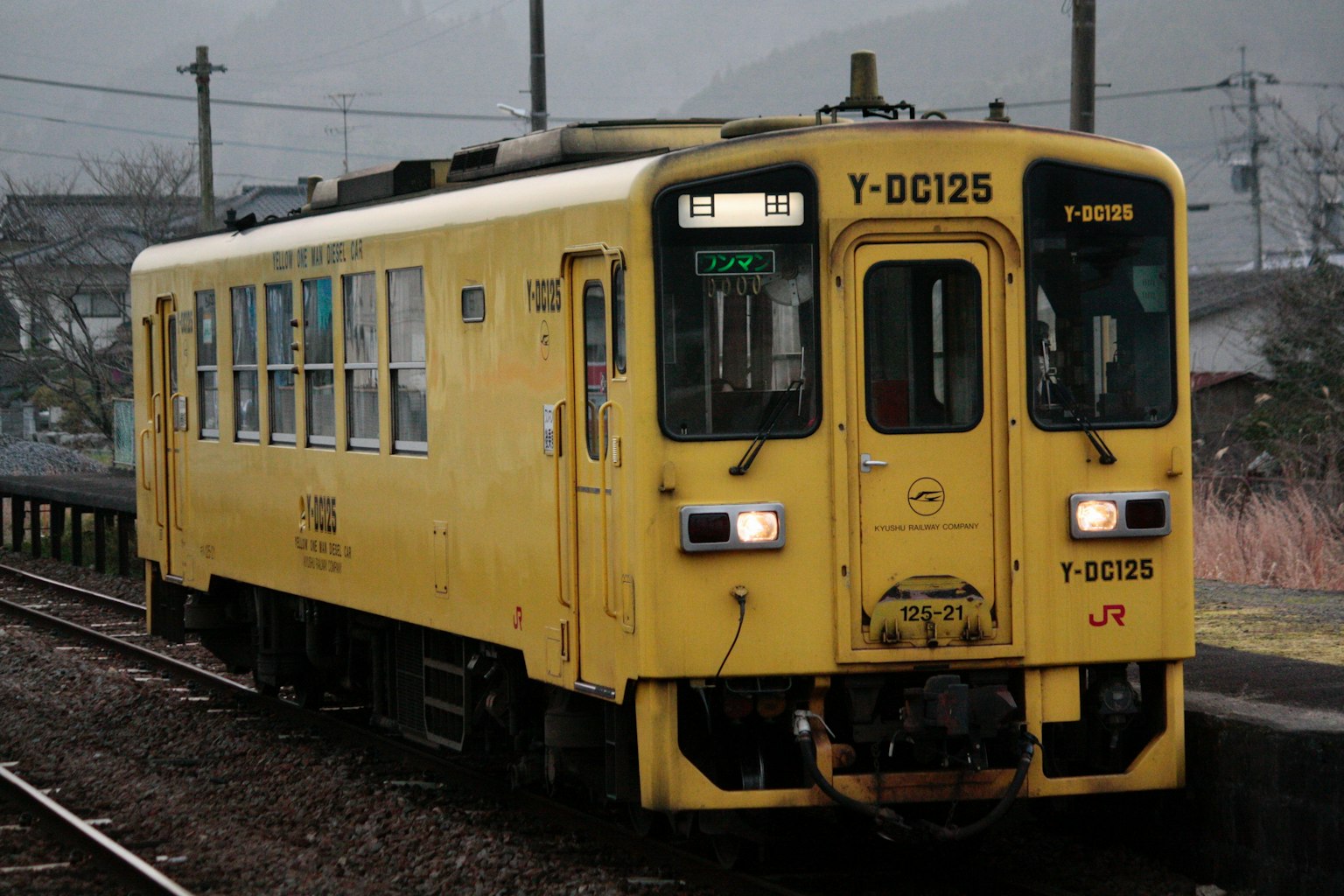 A yellow train stopped at a station