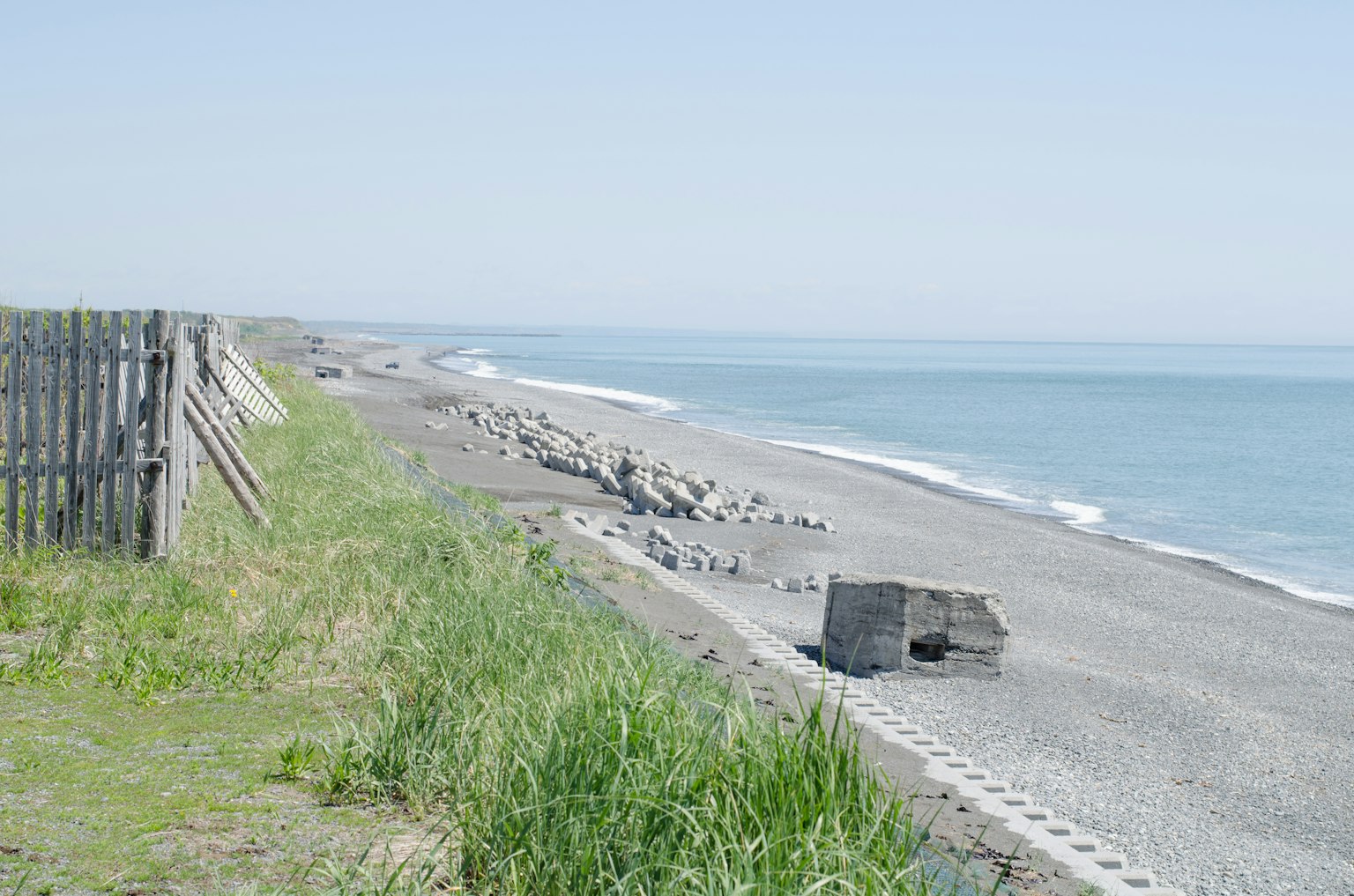 宁静的海滩景观可见海岸线草和散落的石头在砾石海岸上