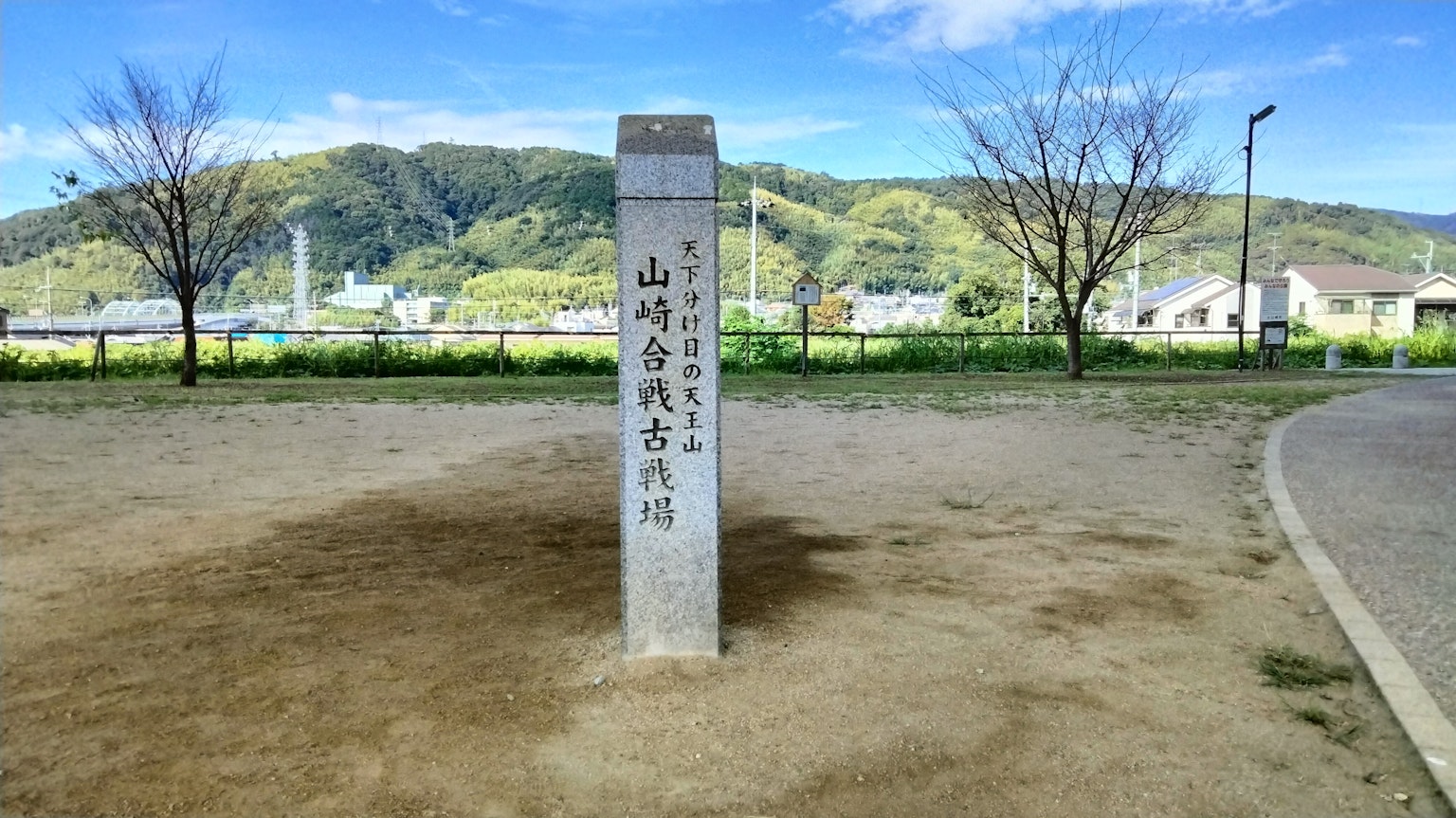 Park scene featuring a stone marker with mountain trail inscription