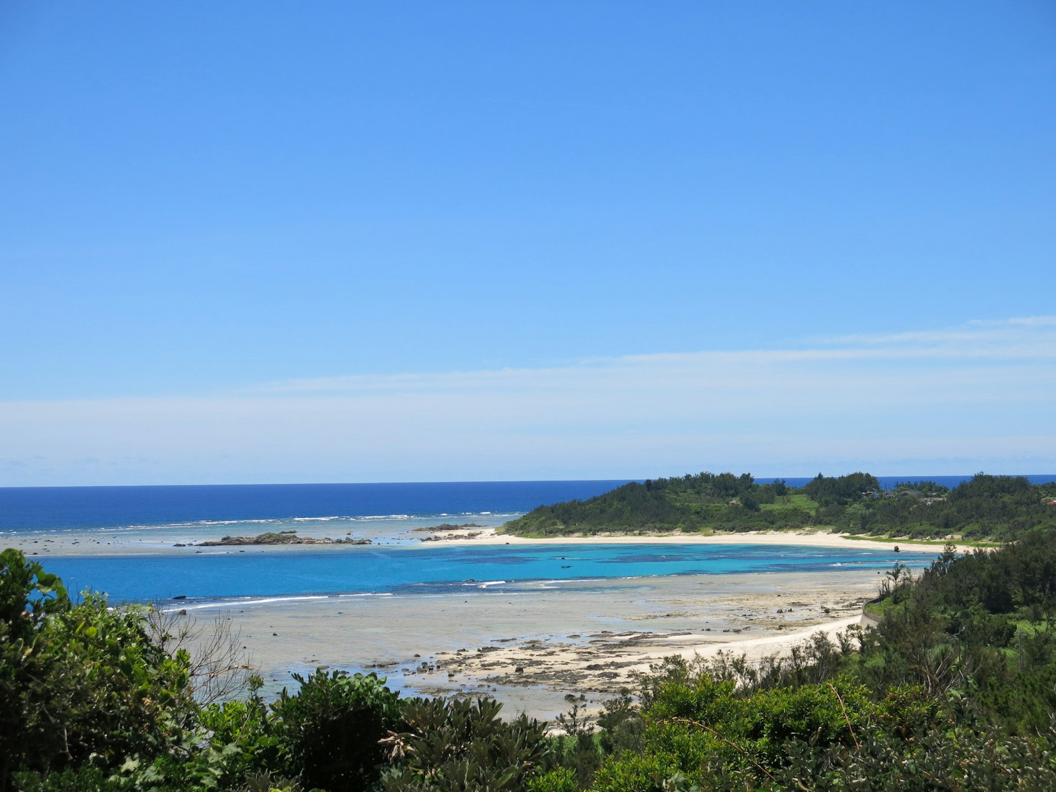 Vista panoramica dell'oceano blu e della spiaggia di sabbia bianca circondata da alberi verdi