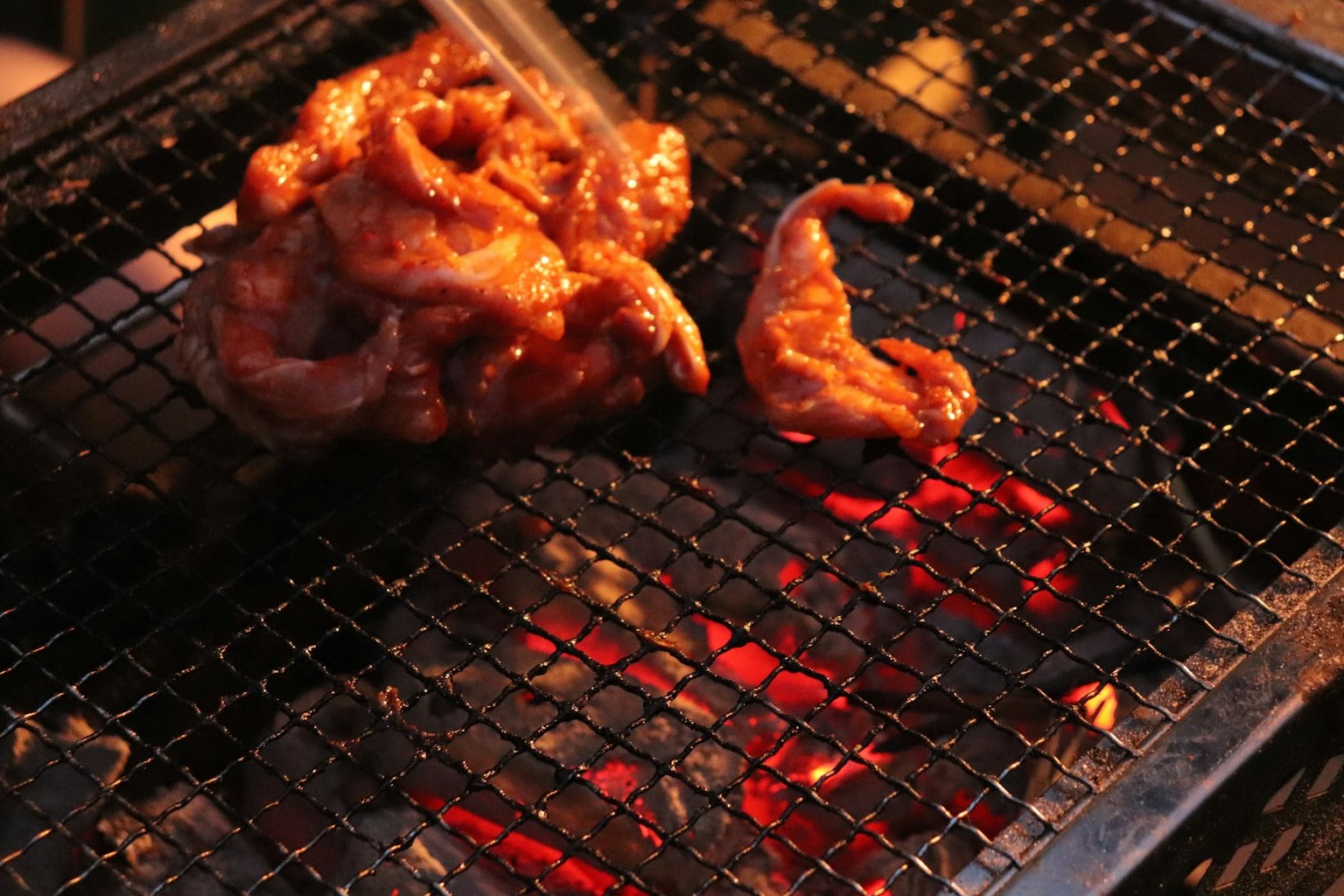 醃製肉塊在炭火上烤制的情景