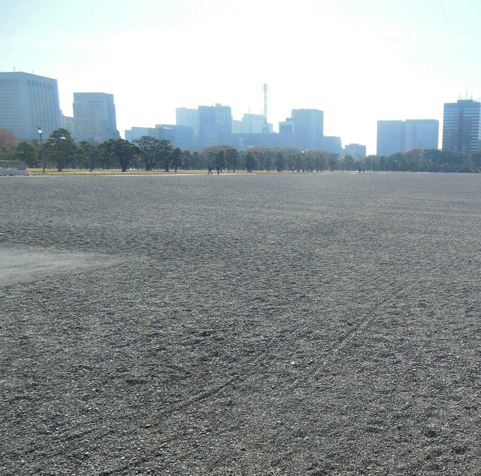 Wide gravel space with skyscrapers in the background
