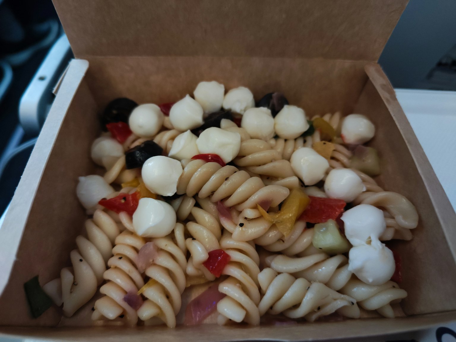 Ensalada de pasta con verduras en una caja de comida de avión