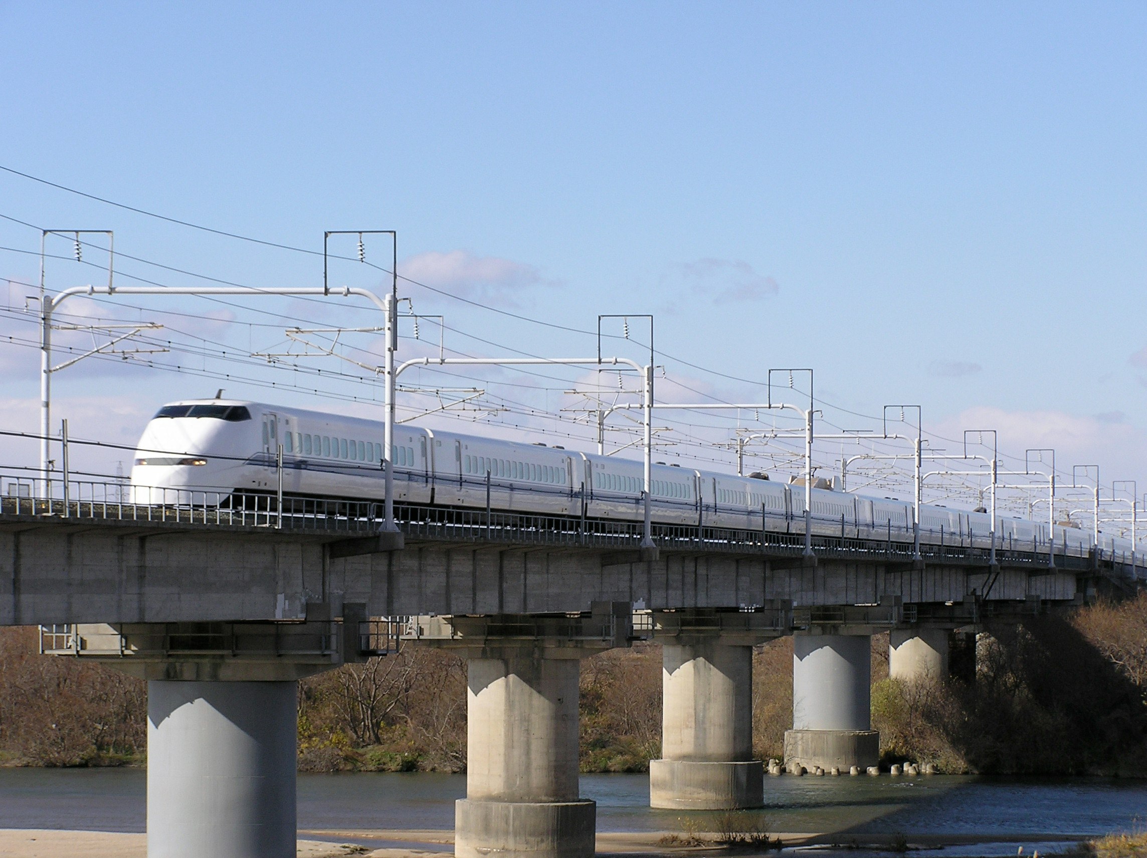 高架橋を走る白い新幹線の車両列