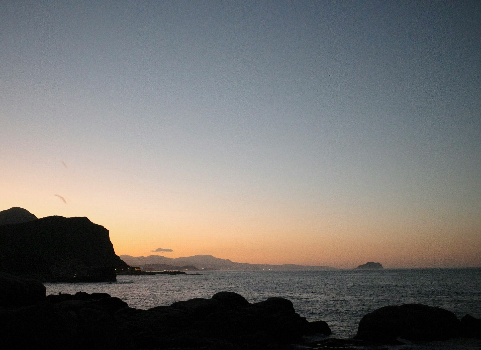 夕焼けの海と岩場の海岸風景