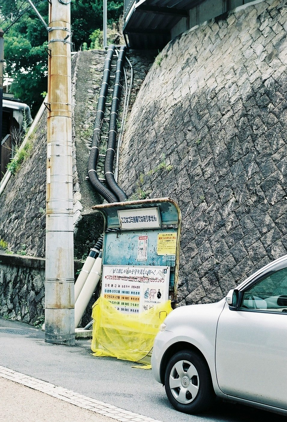 石垣の壁沿いに設置された電気設備と車