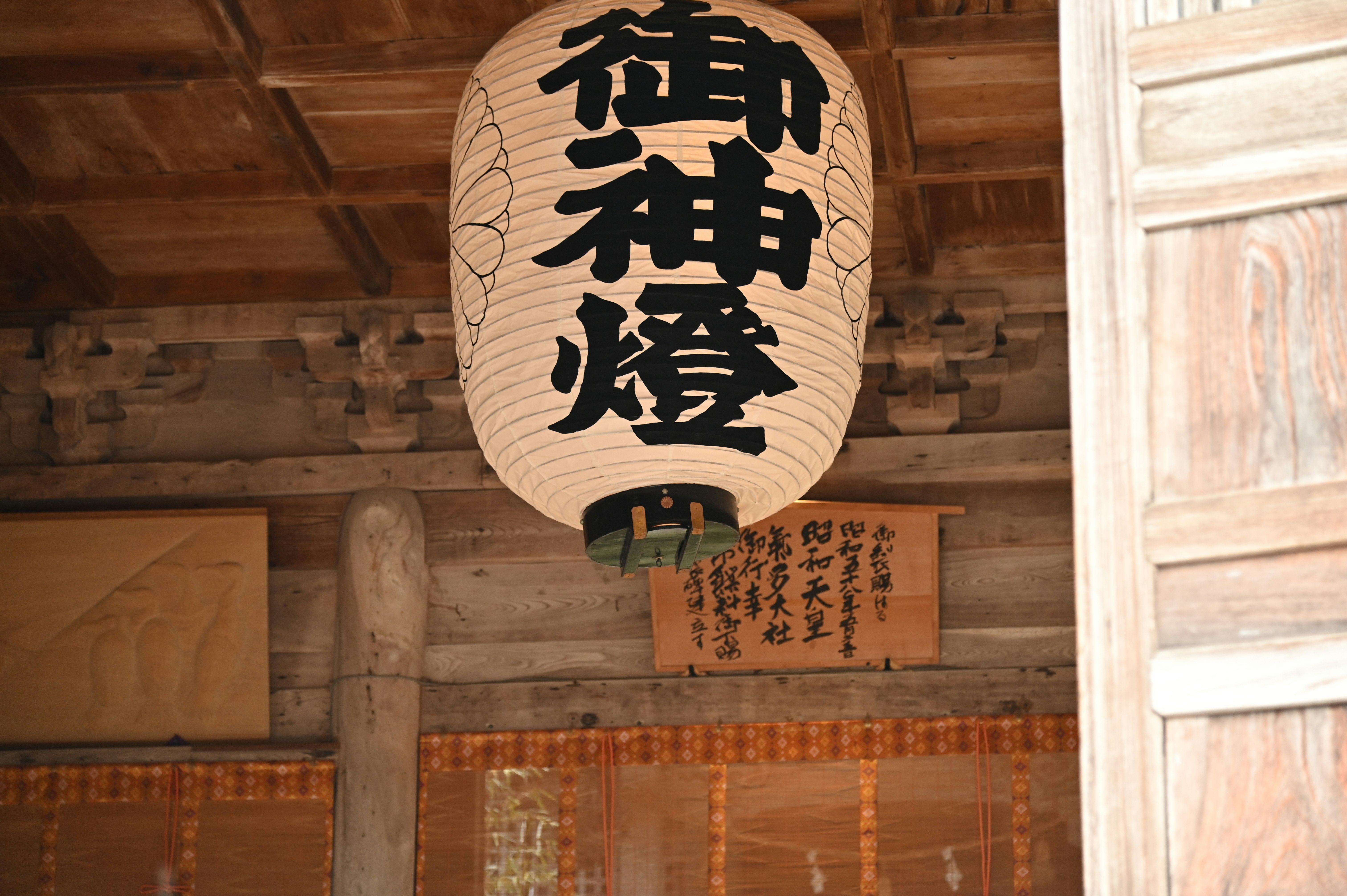 Indoor scene with wooden beams and a lantern with Japanese characters
