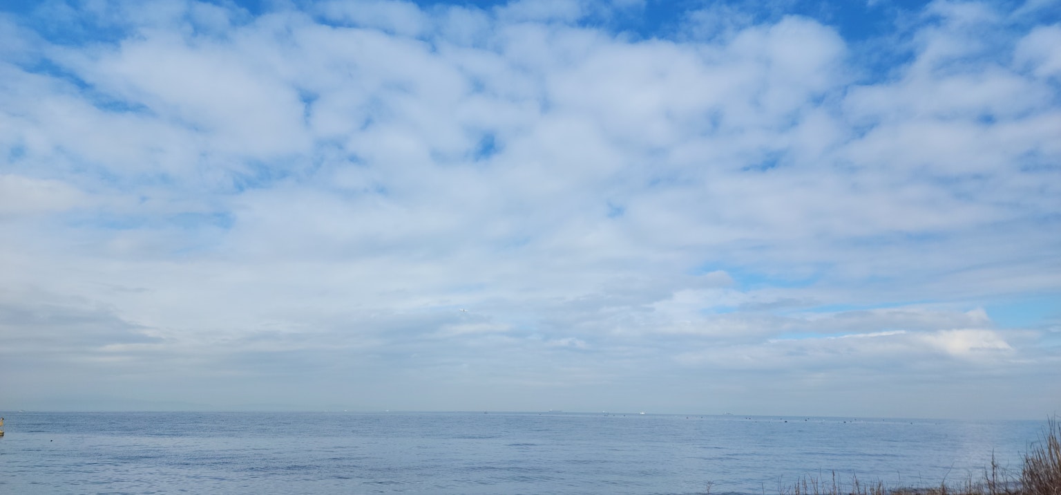 Serene ocean view with blue sky and white clouds