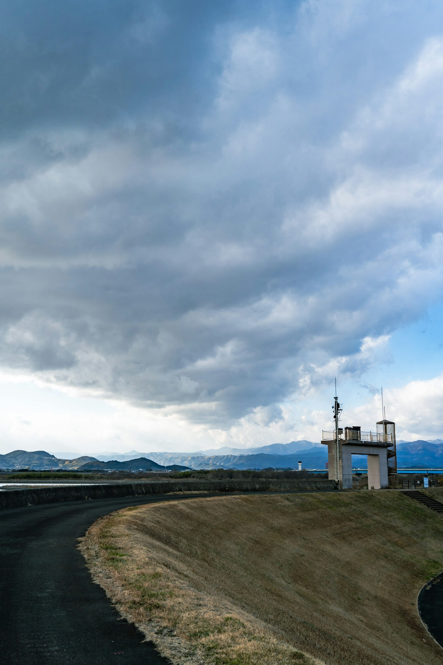 曲折的道路和多雲天空下的監視塔