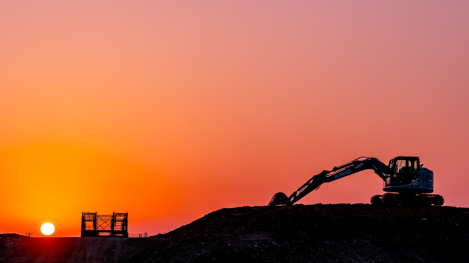 日落时 excavator 在挖土的轮廓