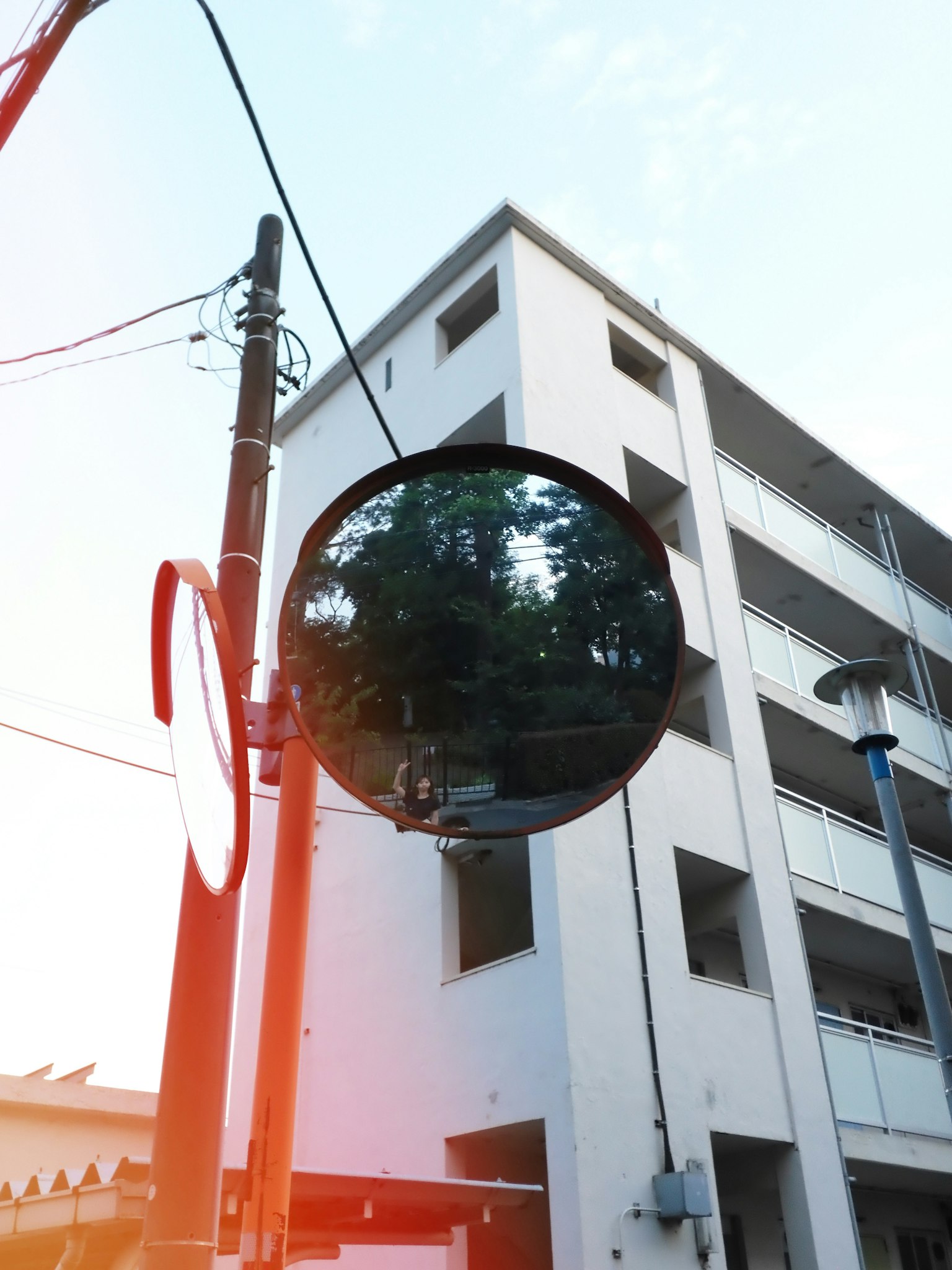 Cermin bulat di sudut jalan yang memantulkan bangunan terdekat