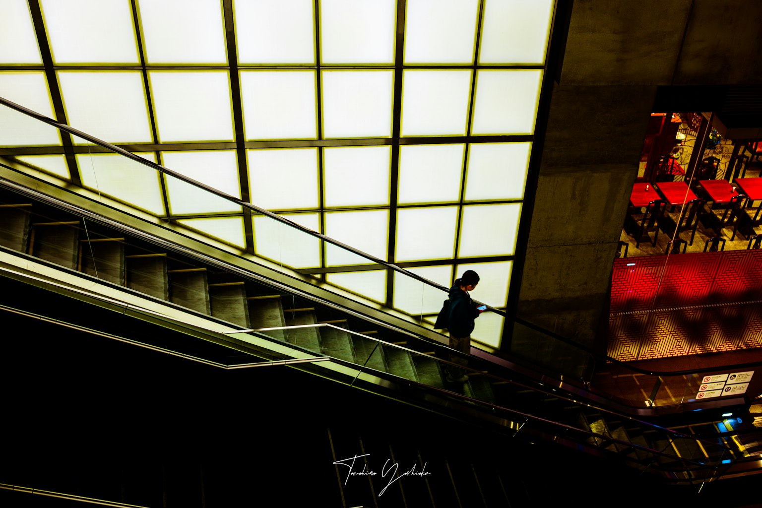 Silhouette di una persona che scende le scale Soffitto luminoso e illuminazione rossa in una scena della metropolitana