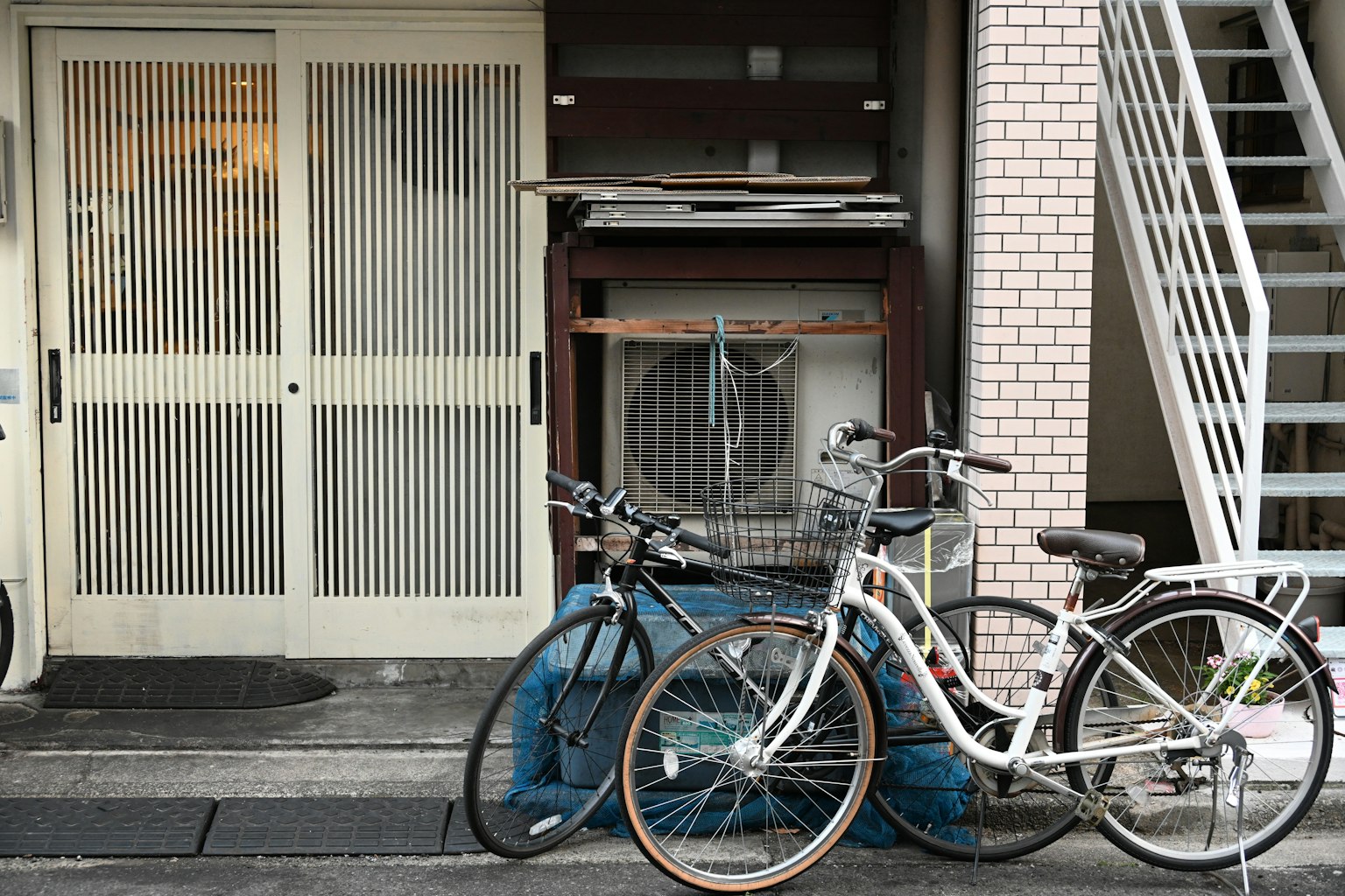 Une scène avec un vélo blanc et un vélo noir devant un appartement