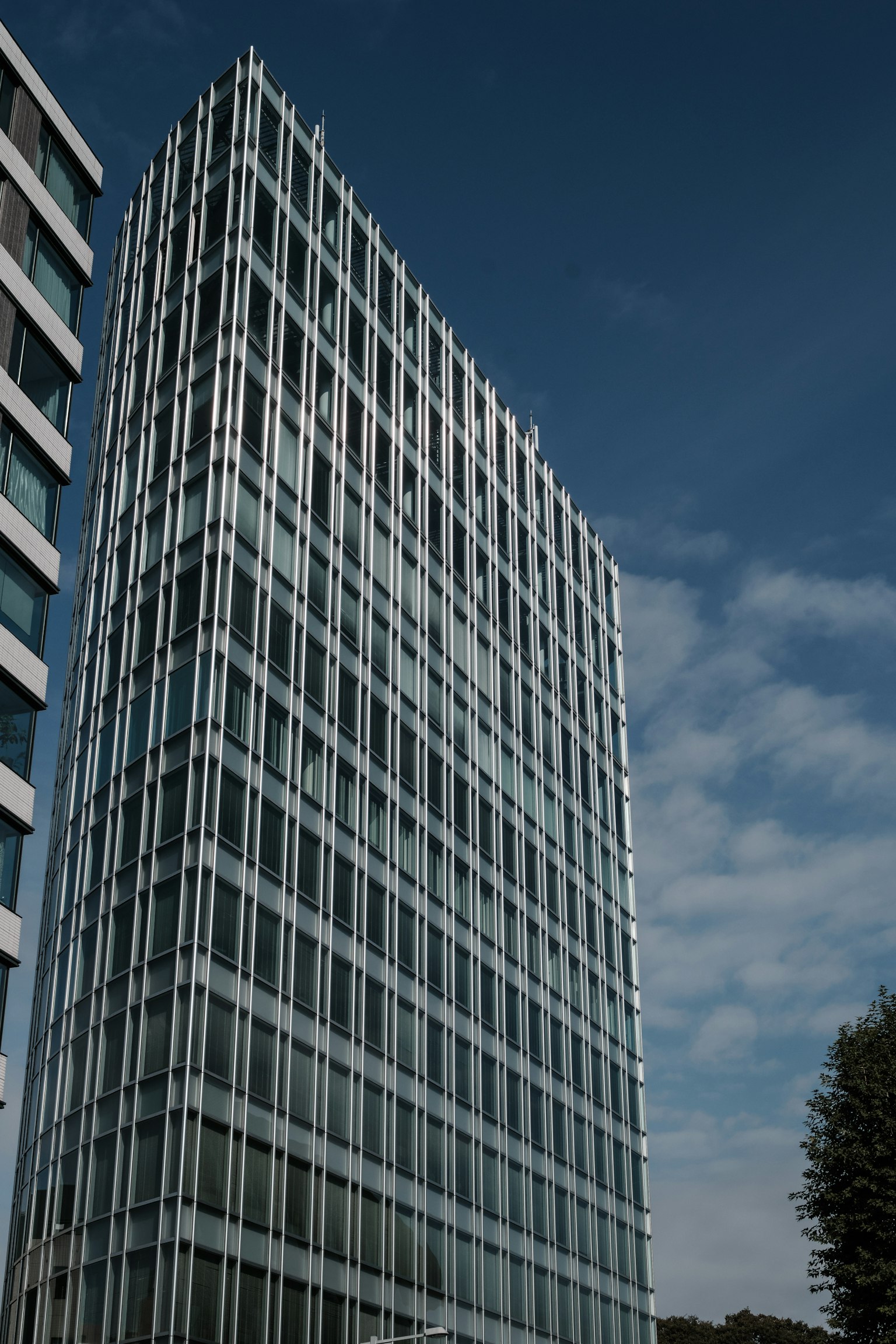 Edificio moderno in vetro che si erge sotto un cielo blu