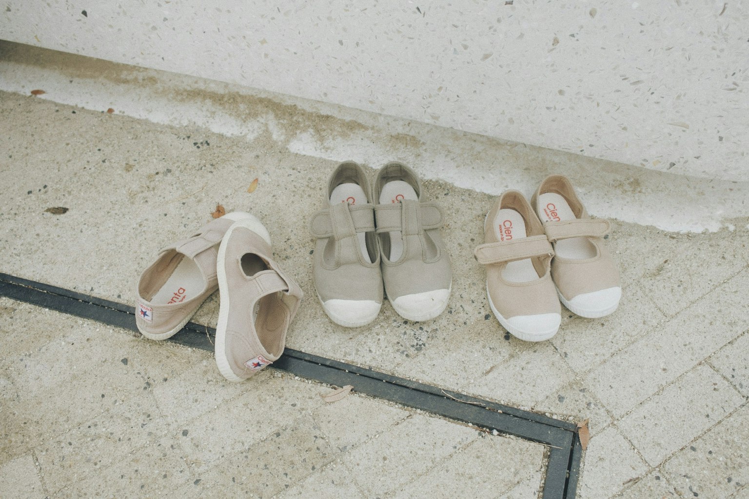 Sneaker beige e grigie disposte su una superficie testurizzata