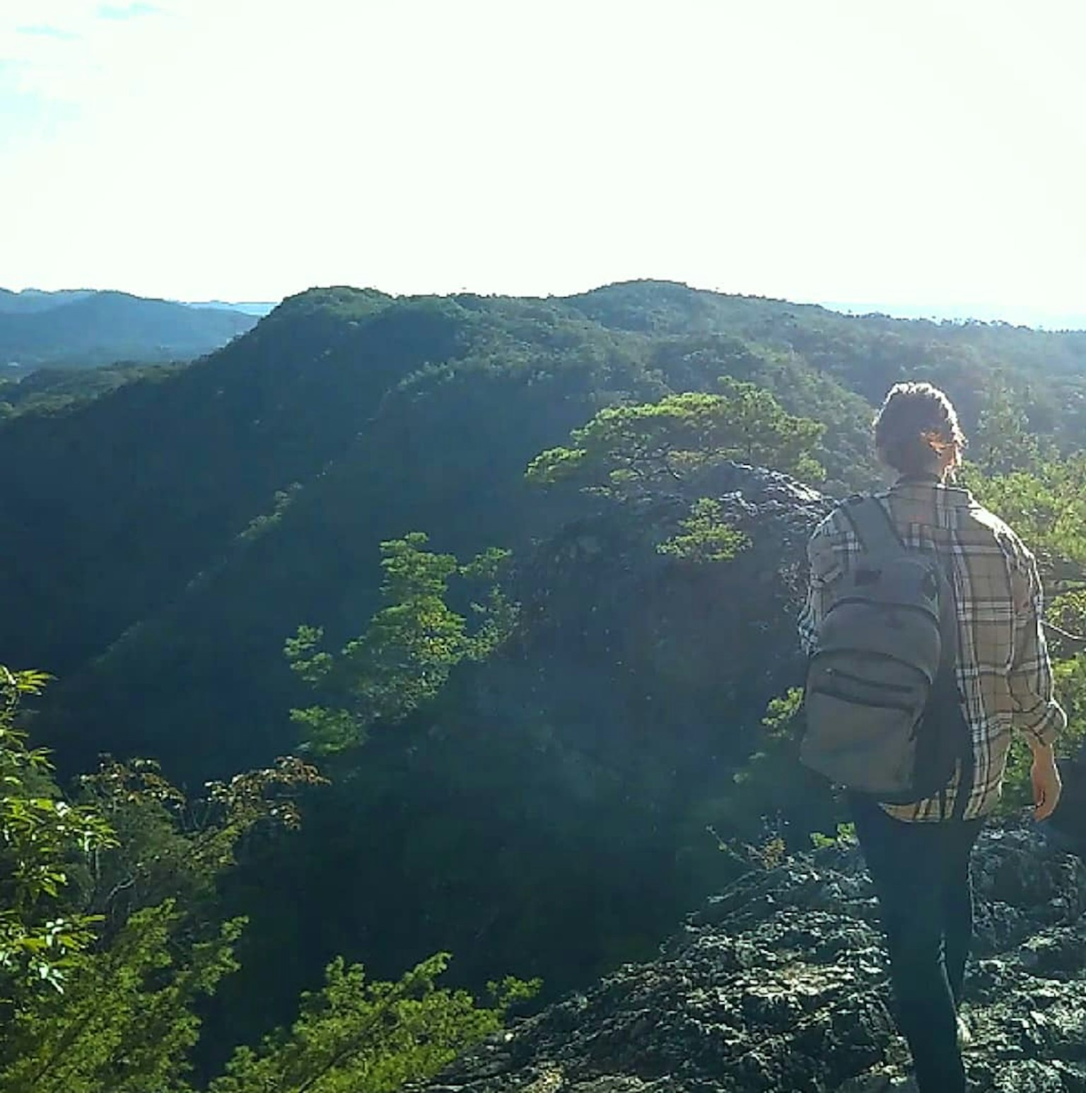 Une personne debout au sommet d'une montagne surplombant un beau paysage